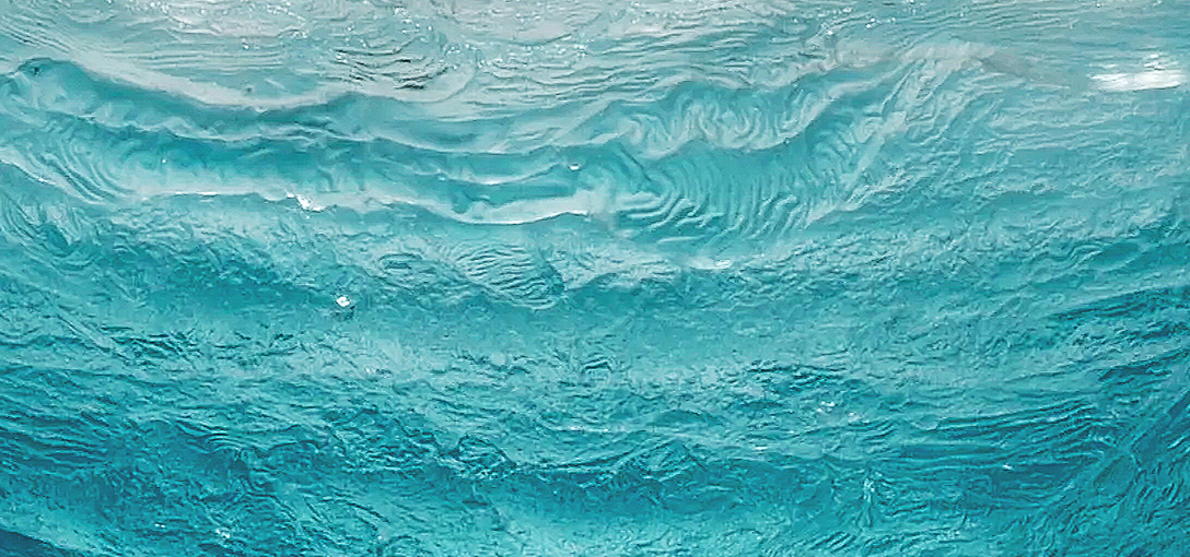 Close-up of blue water surface with ripples and waves.