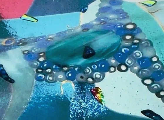Colorful children's playground with a slide and a climbing structure surrounded by a blue and gray rubber safety surface.