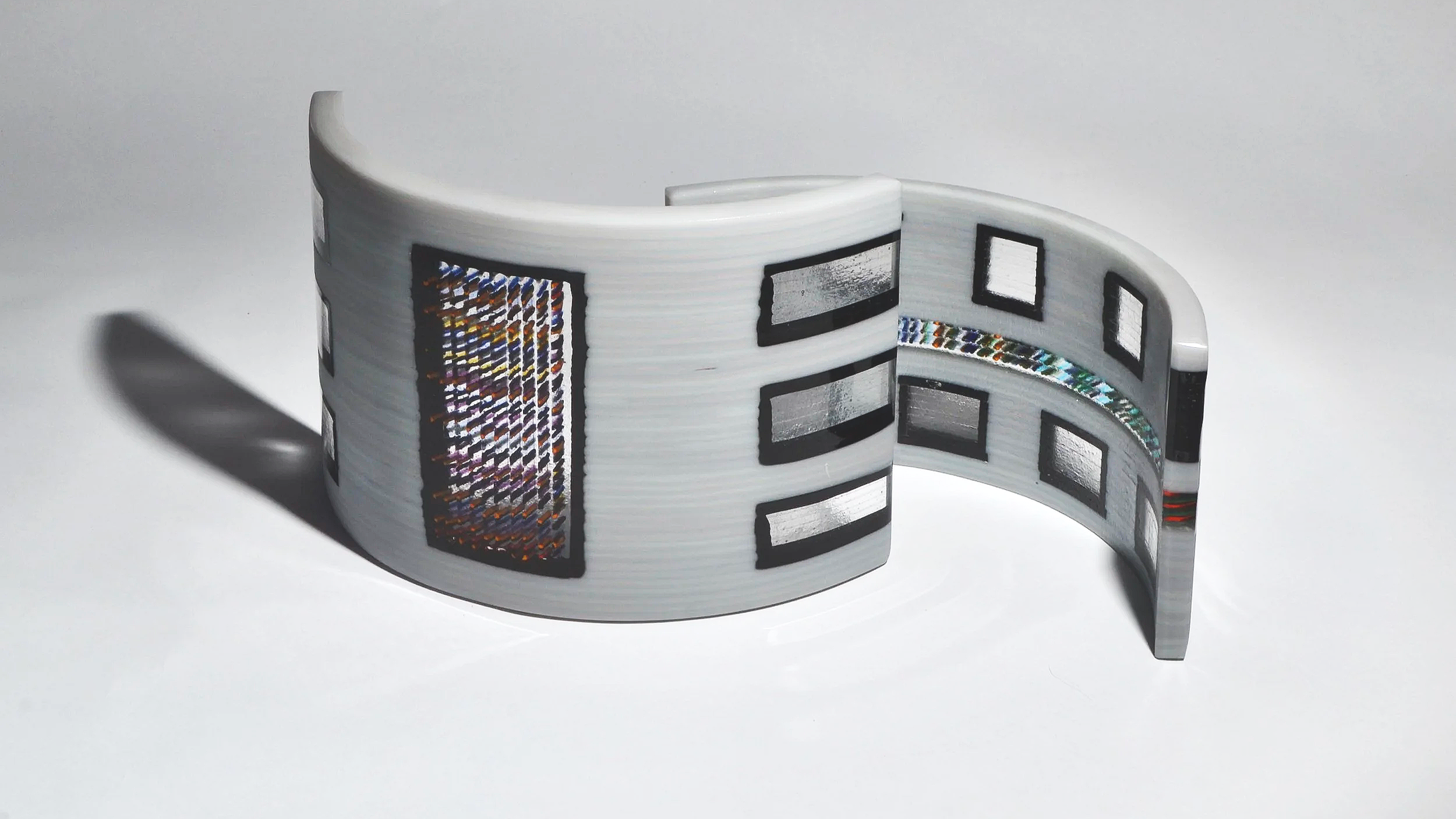 A flexible sheet of electronic display design with multiple rectangular and holographic sections, possibly for a foldable or rollable device.