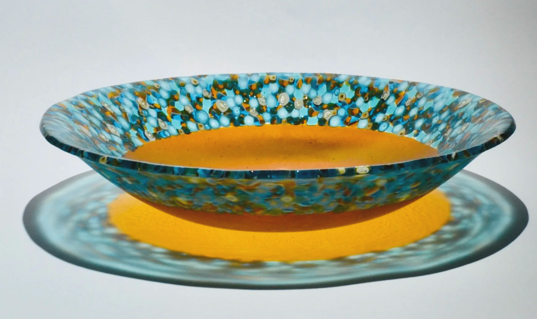 Gathering Bowl - amber - an amber glass bowl surrounded by hand pulled blue, white and amber murrine - side view.