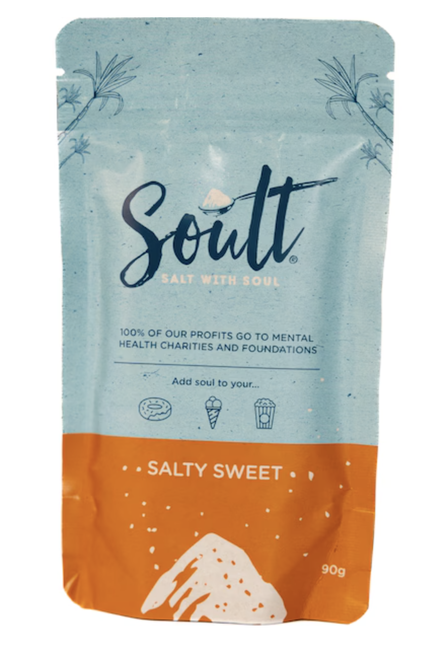 A bag of salt with branding called 'Soult', labeled as 'Salt with Soul'. The package is blue and orange with a white illustration of salt and has text indicating that all profits go to mental health charities. The salt flavor is described as 'Salty Sweet'.