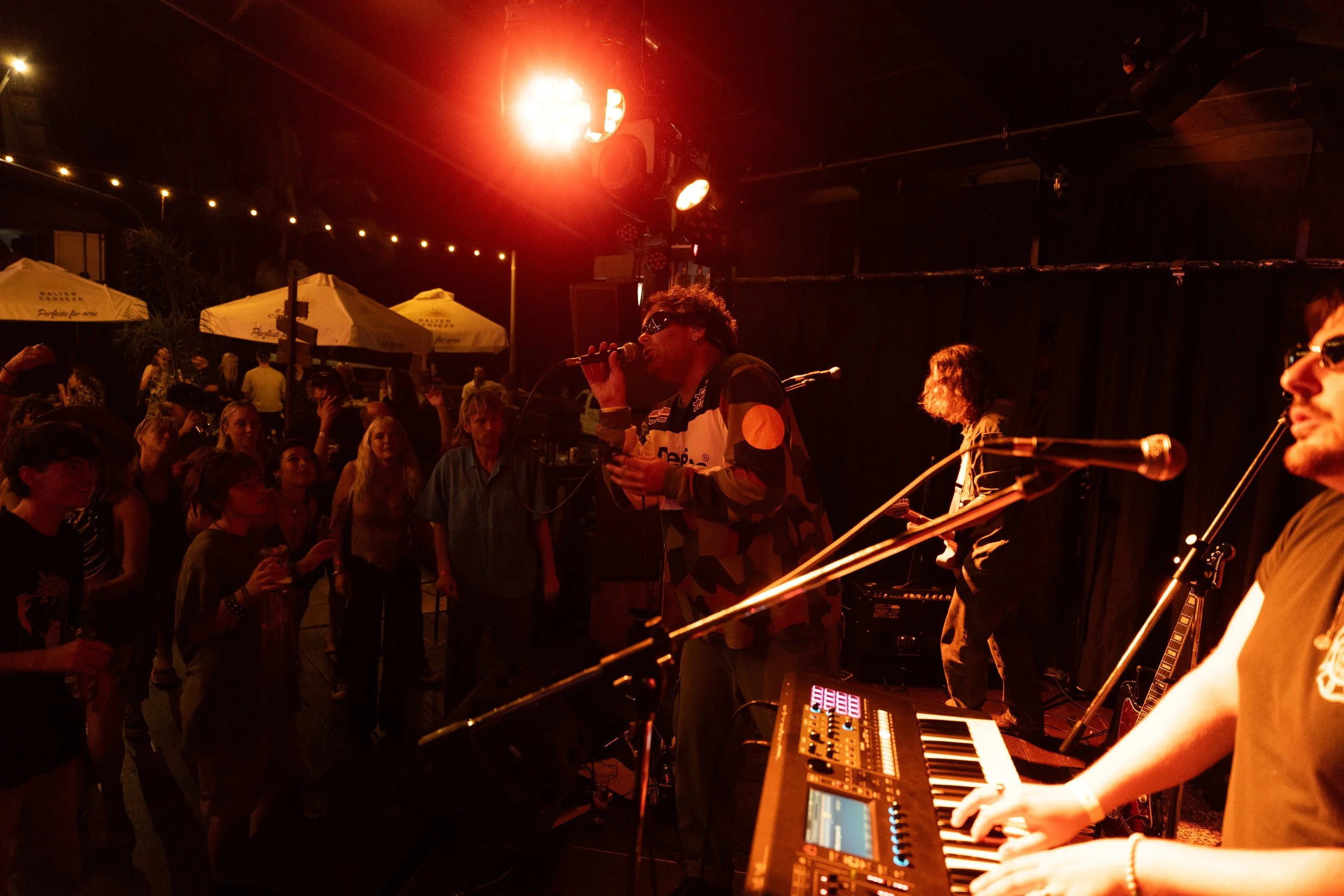 Musicians performing on stage at a concert, with audience dancing and enjoying themselves.