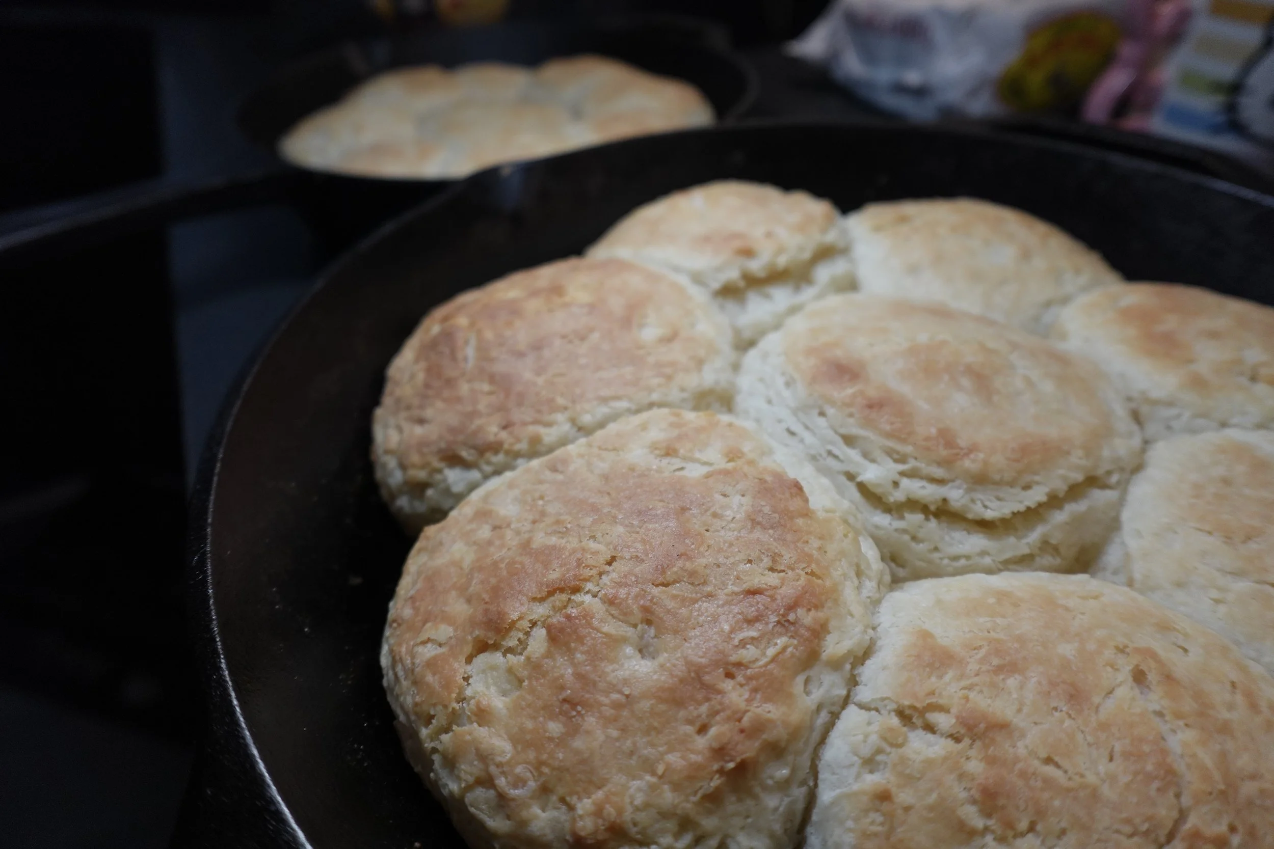 Close-up of freshly baked biscuits in a black skillet.