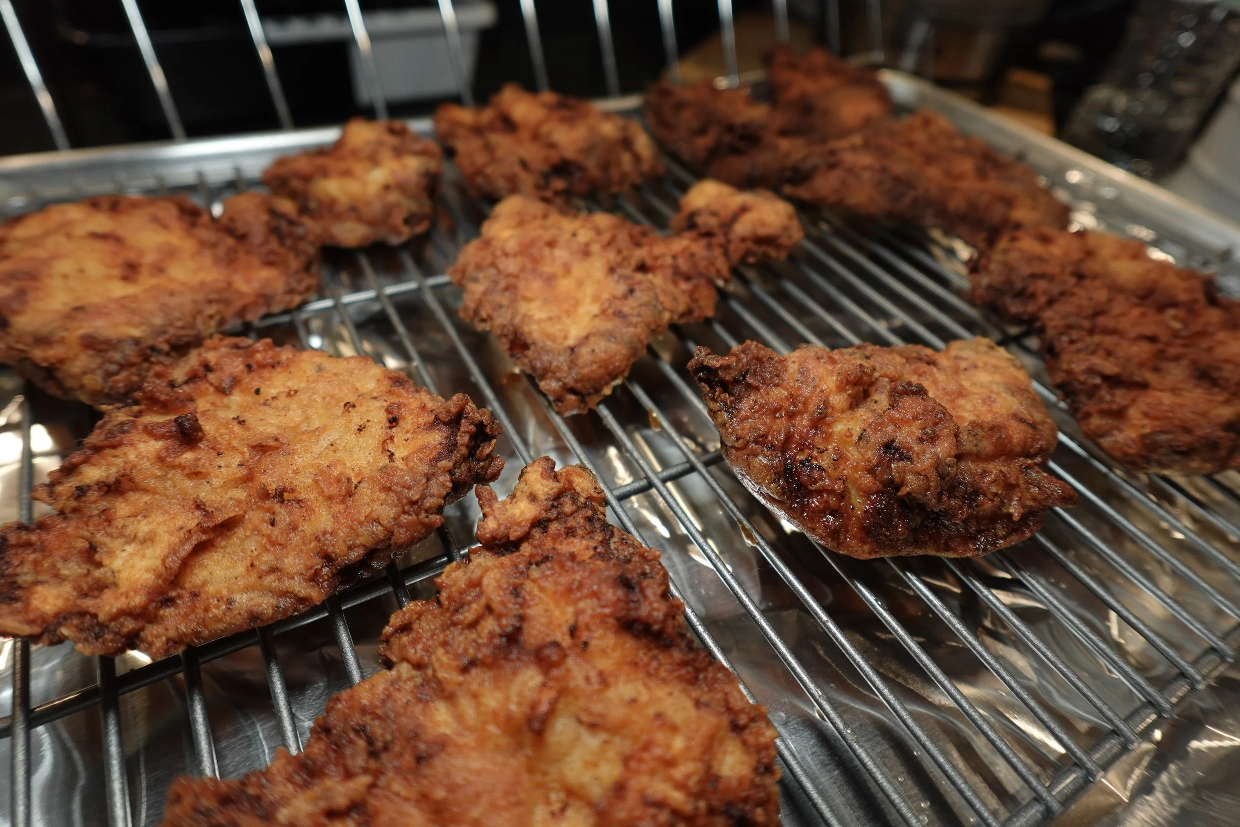 Fried chicken pieces on a metal rack