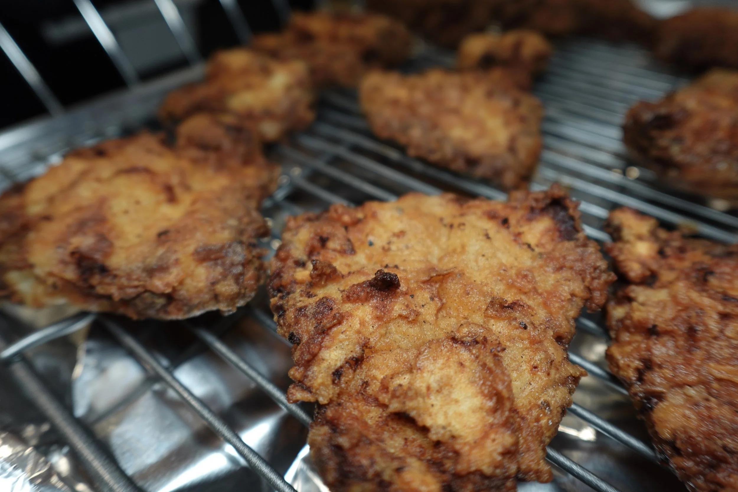 Fried chicken pieces on a wire rack
