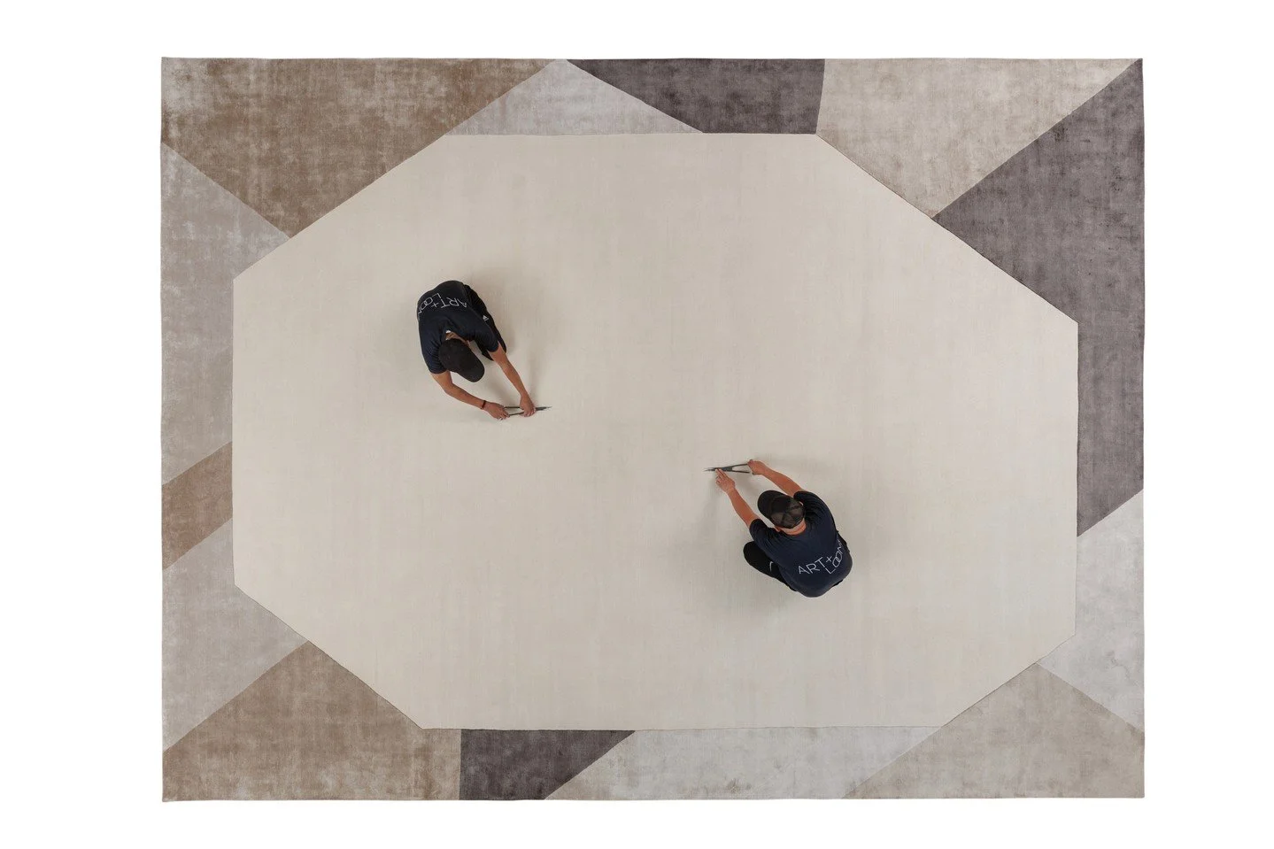 GROUNDWORK RUG.⁠
⁠
Groundwork by Art + Loom is built around a vast central field&mdash;an expanse of wool bordered by angled planes of silk in warm taupe, pale gray, stone and charcoal. The geometry gathers at the edges, creating a sense of movement 
