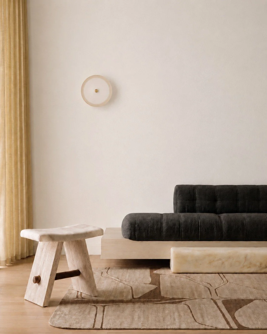 MATERIAL MIX. Softness gets a little more structure here. The Anna Sofa and Celeste Stool from @artandloom x @manifesteedition Alchemy collection layer upholstered forms with stone and wood, while Art + Loom&rsquo;s Ondula Rug echoes the same irregul