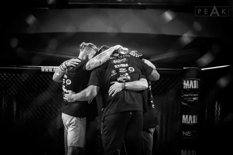 Australian Elite Team Northside fighters embracing inside MMA cage after professional bout