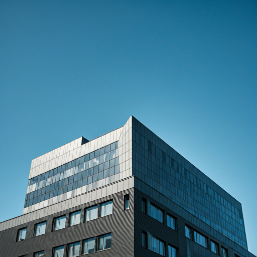 A modern multi-story office building with reflective glass windows against a clear blue sky.