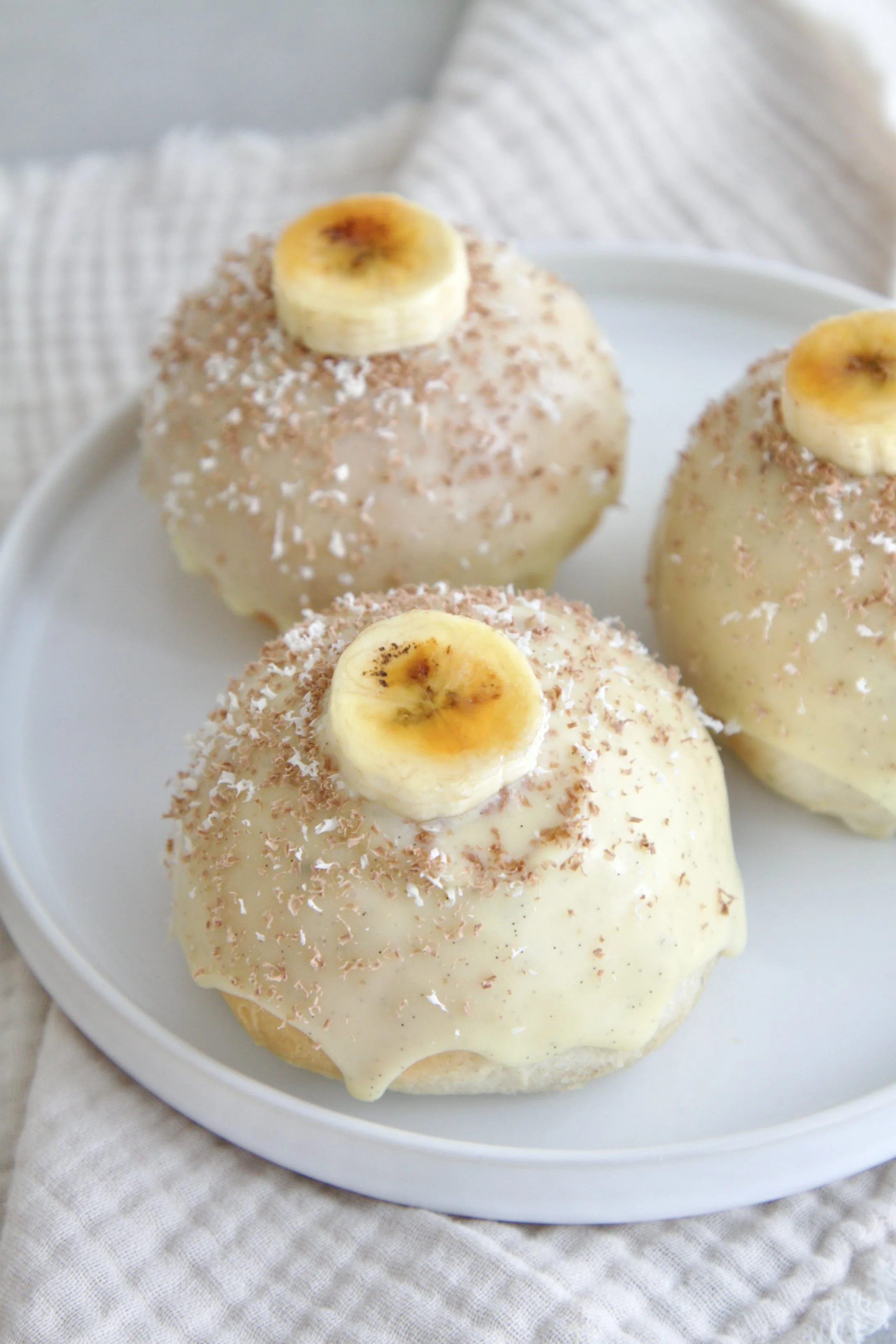 3 banoffee cream buns from the top with pieces of caramelized banana slices and chocolate shavings