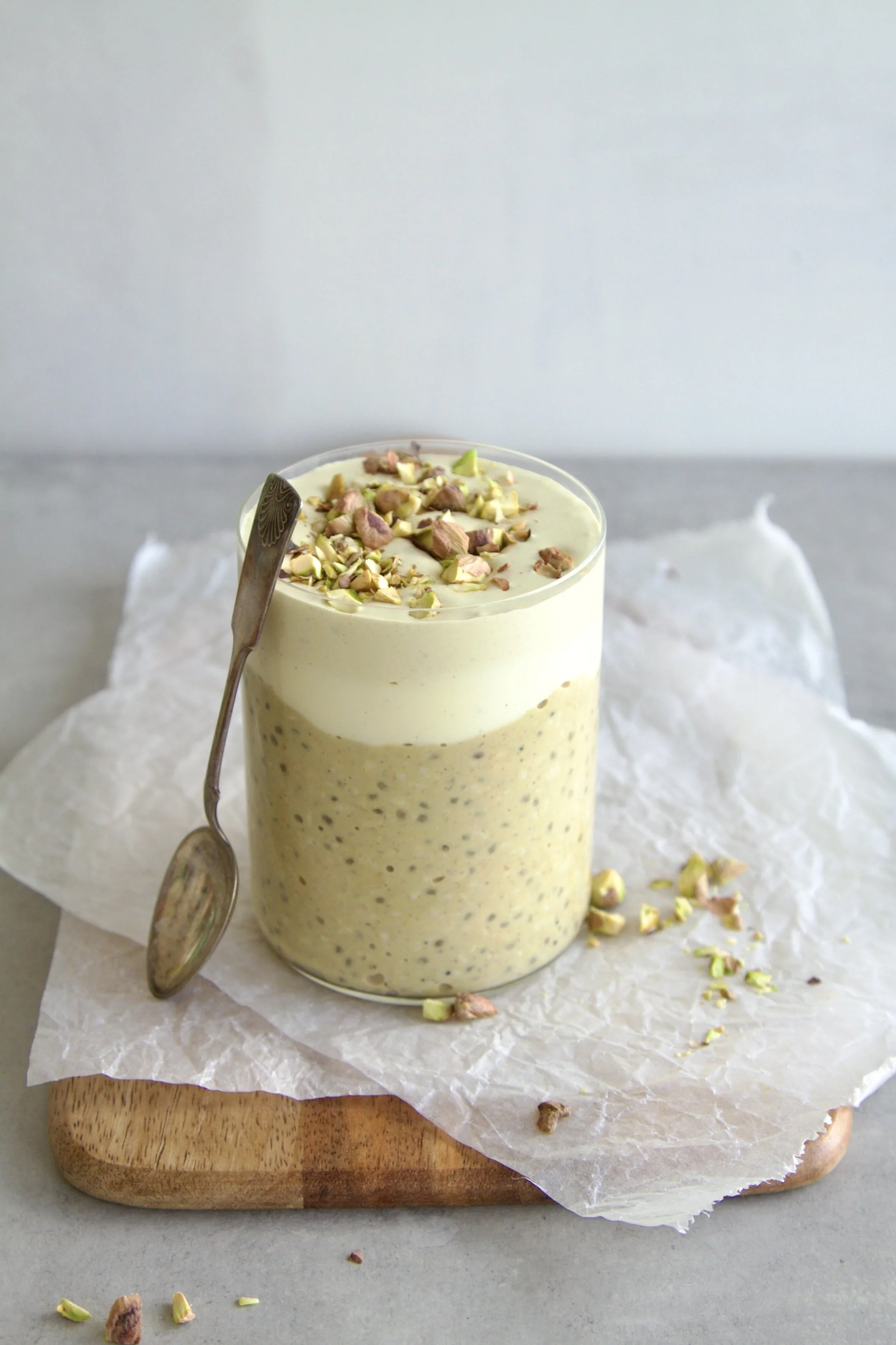 glass filled with pistachio overnight oats topped with crushed pistachios