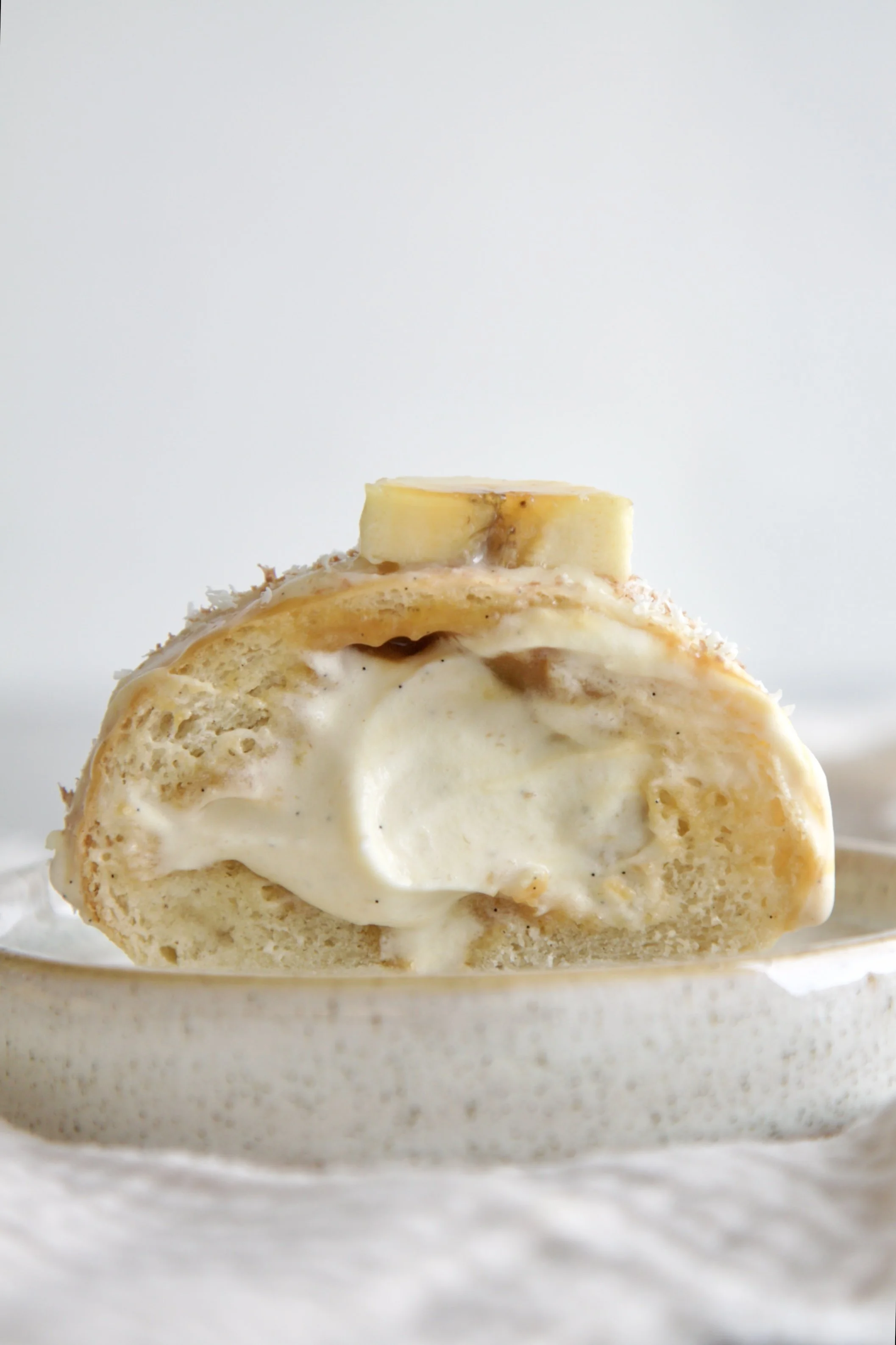 cut of a banoffee cream bun to see the inside filling of banana cream and caramel