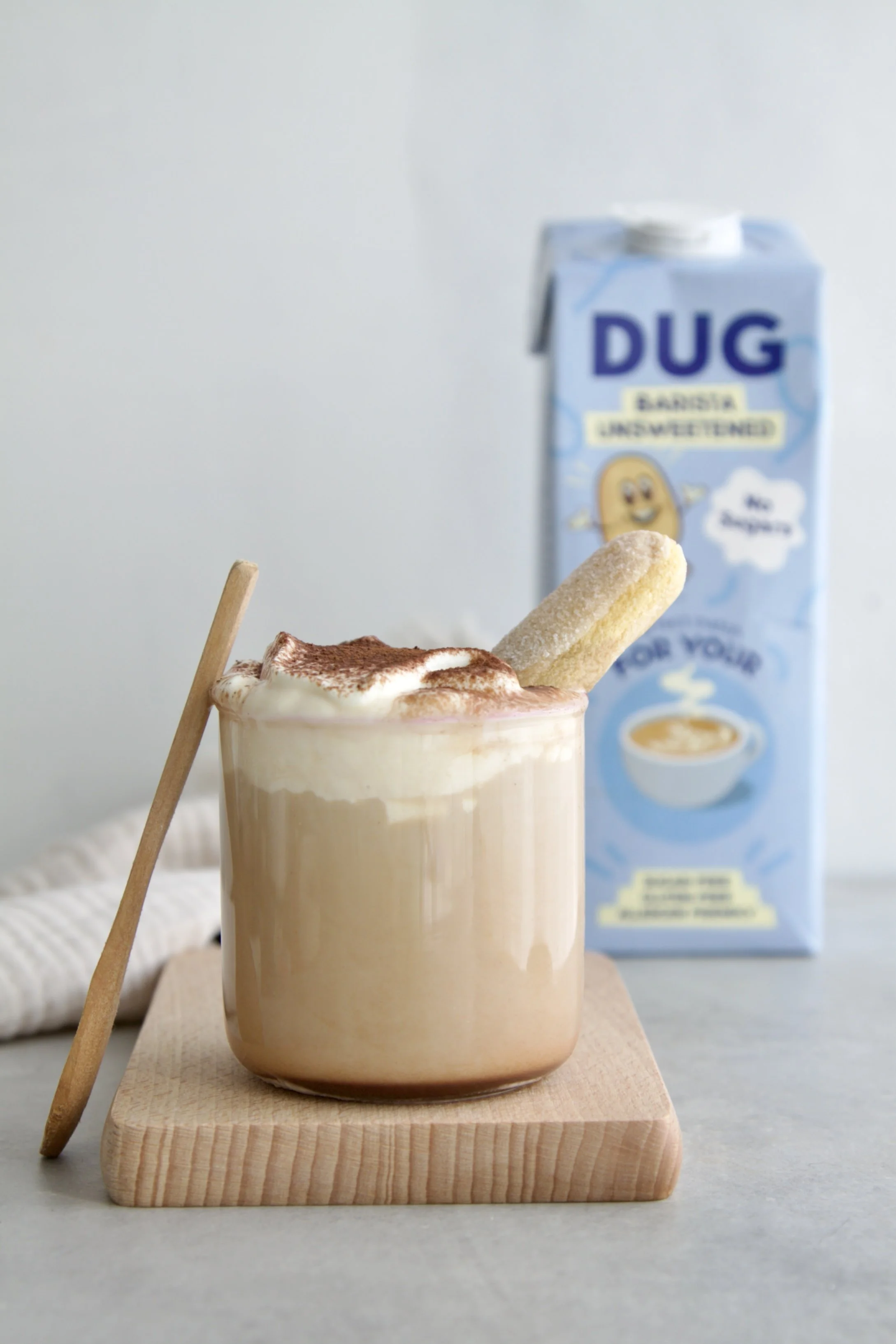Glass of tiramisu latte with a dug drink milk in the background