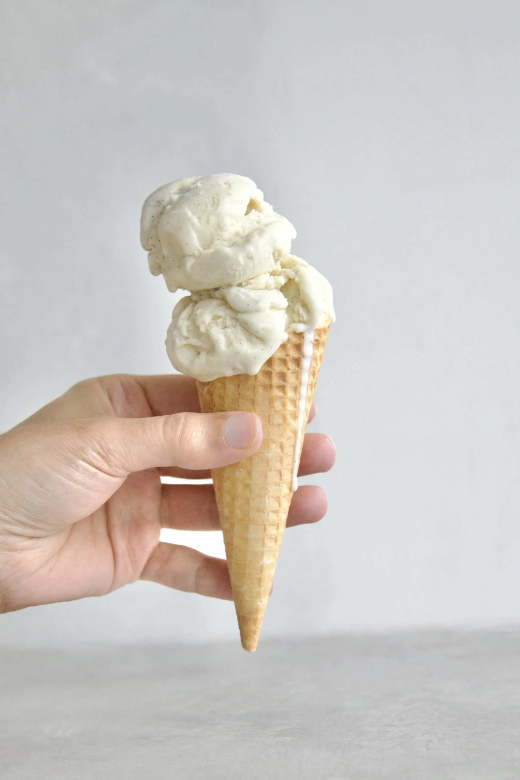 ice cream cone filled with scoops of vanilla ice cream