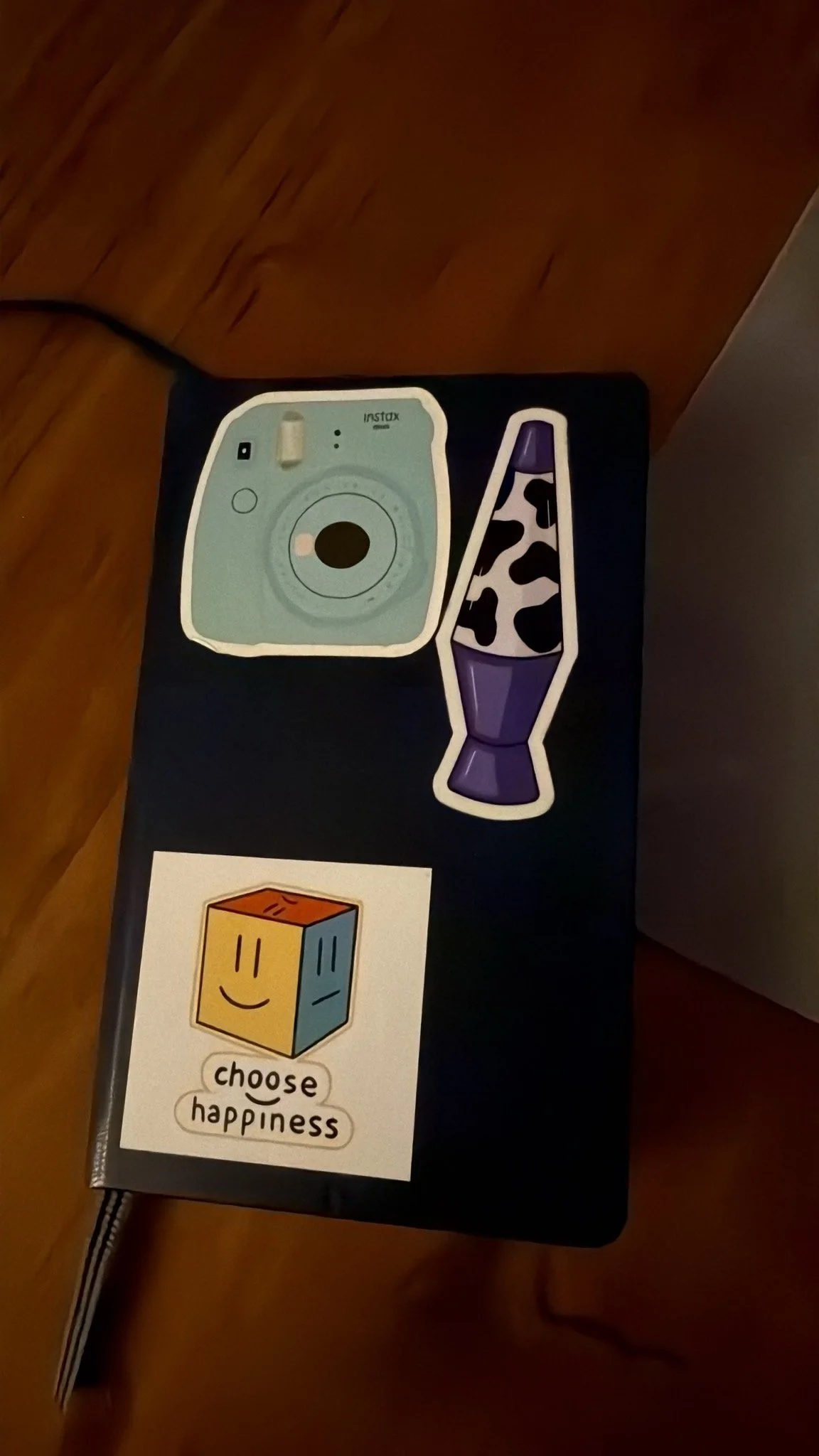 Symbolbild mit einer Kamera, einem Lavastein und einem Würfel mit einem lachenden Gesicht, darunter steht der Slogan 'choose happiness'.