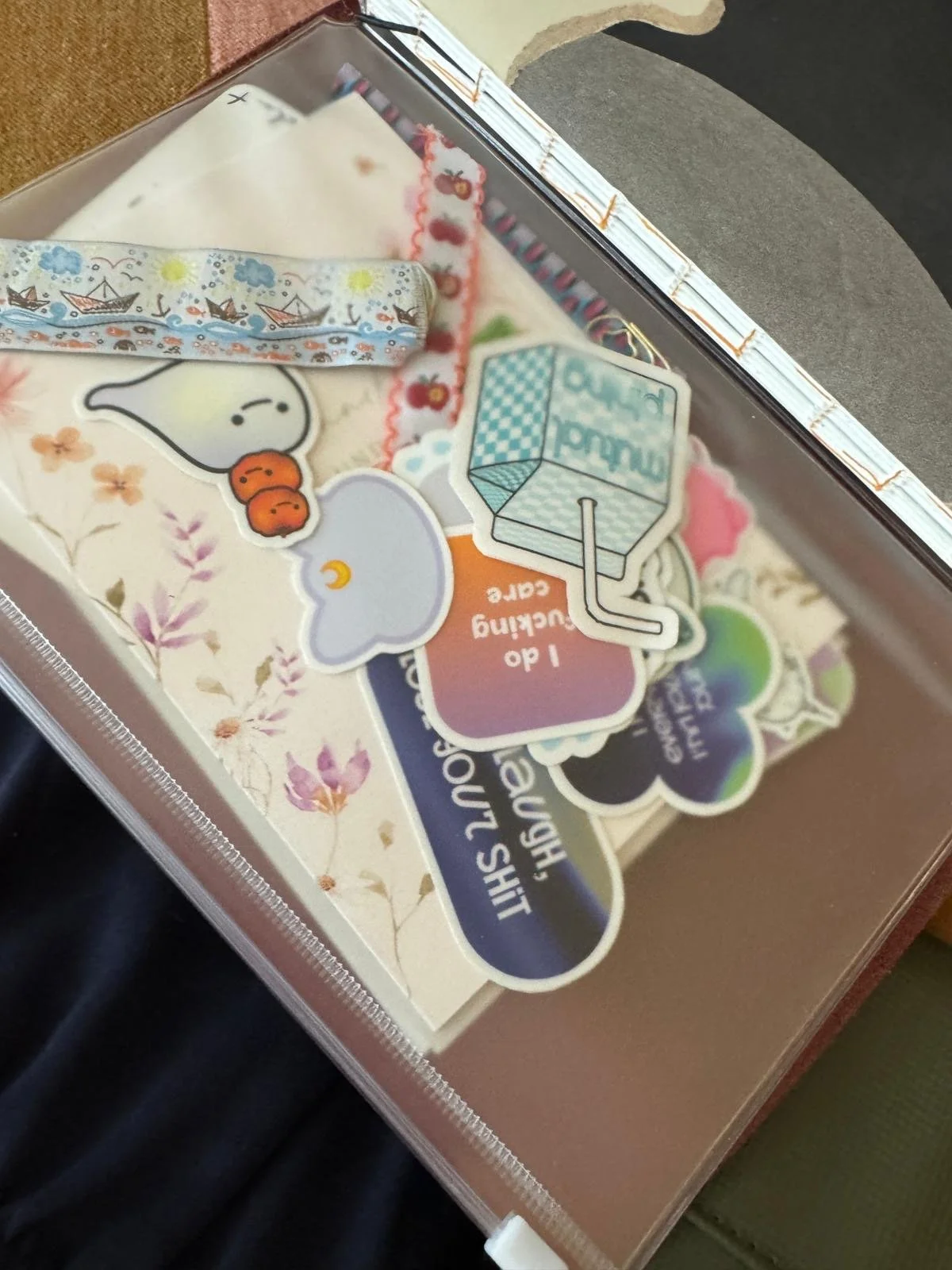 Eine Box mit verschiedenen bunten Aufklebern, darunter ein Trinkhalm-Design, ein Wolkenbild, eine Figur mit Orangen, und der Text 'I do *something*'.