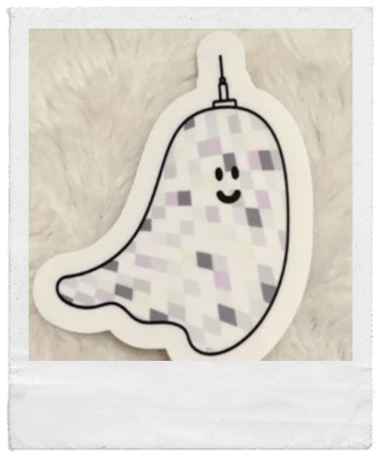 Ein Sticker in Form eines blinkenden, pixellierten Geistes mit freundlichem Gesicht auf einem weißen, pelzigen Hintergrund.