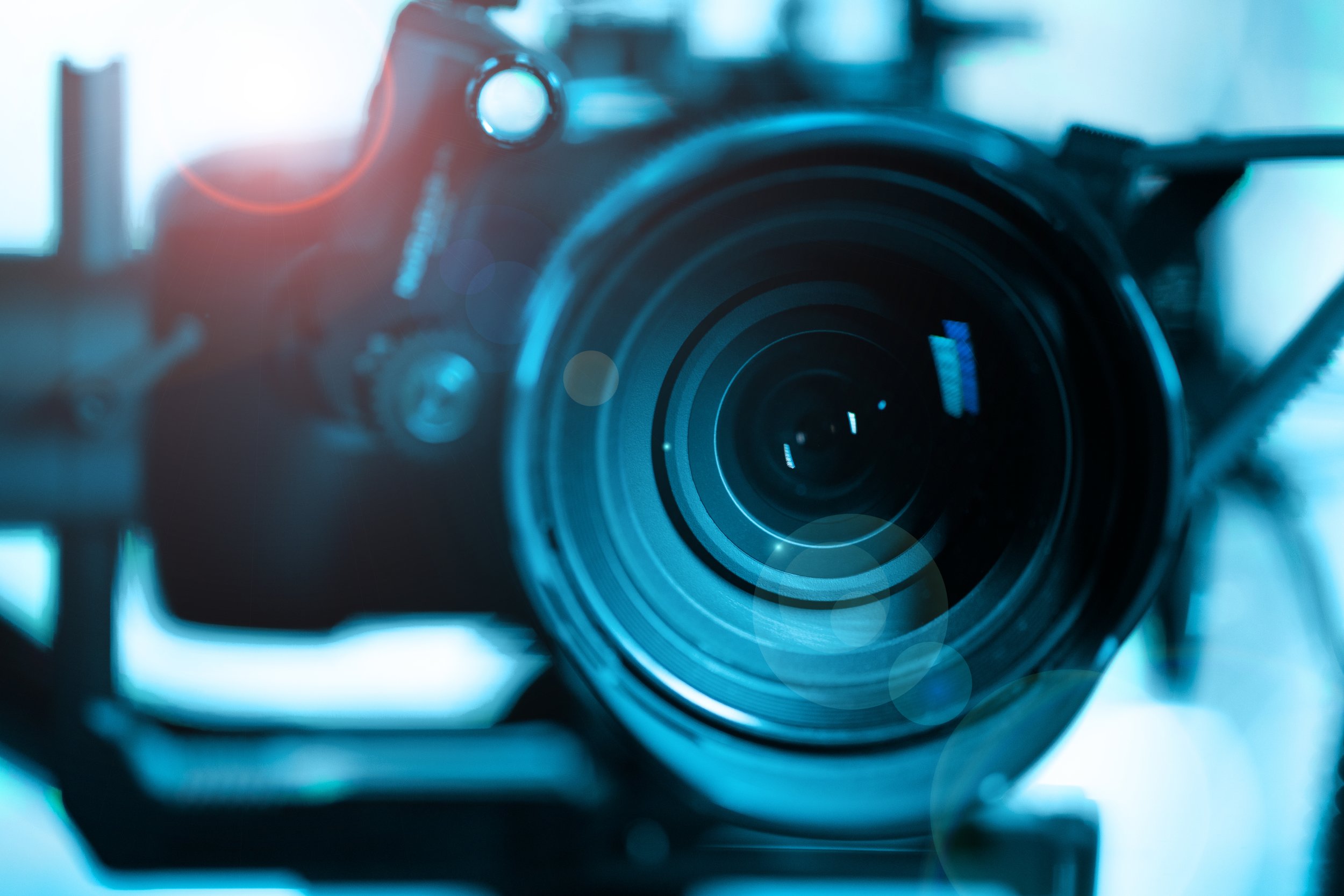 Close-up of a professional camera lens with a blurred background.