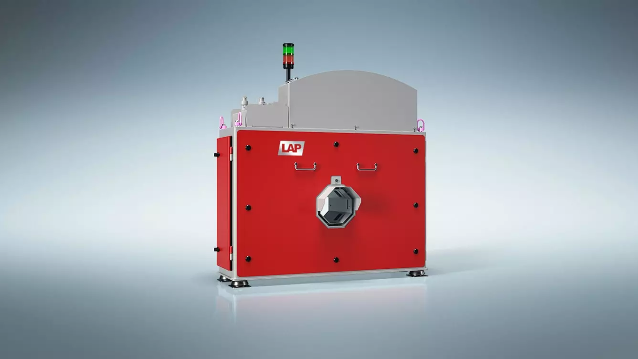 A red and gray industrial machine with a green and red signal light on top, labeled 'LAP', with a hexagonal opening in the front.