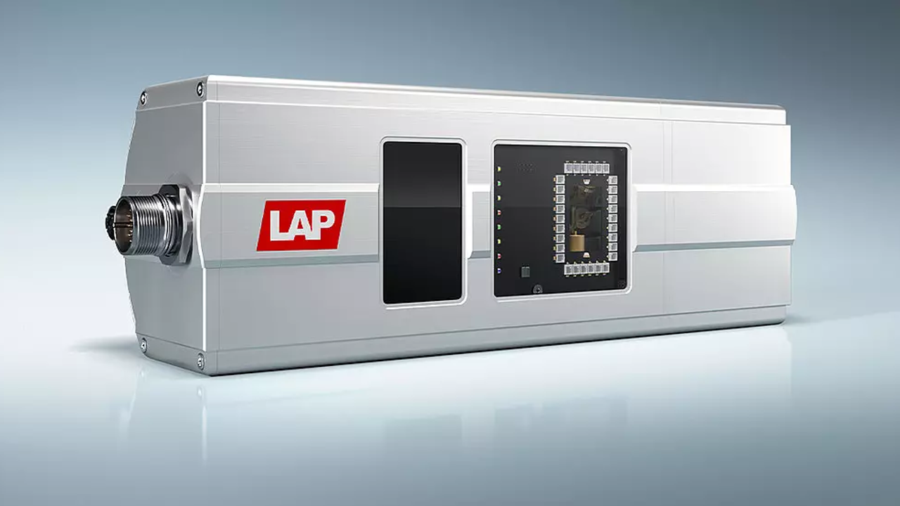 Close-up of a scientific instrument with a silver metallic body, a label reading "LAP" in red and white, and various connectors and a digital display panel.