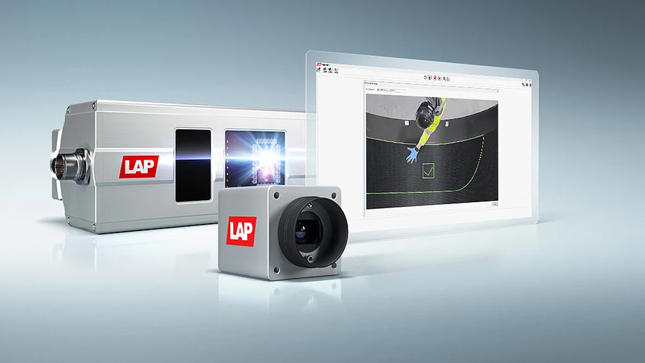 Industrial imaging equipment with the LAP logo, including a camera, a projector, and a monitor displaying a person in protective gear working on a surface.