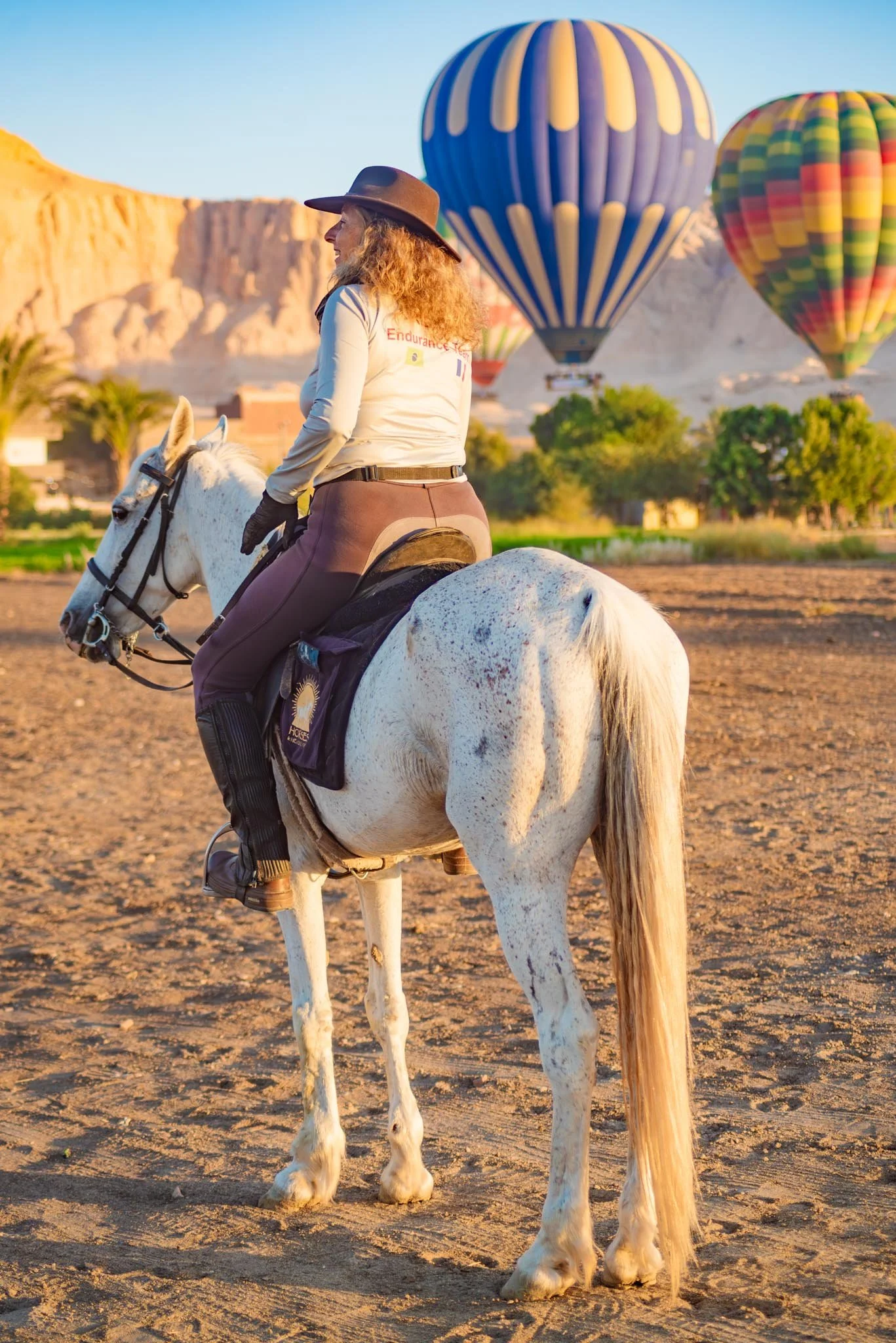 A women enjoying her early morning horse riding trip in Luxor, seeing the colourful Hot air balloons go up at sunrise