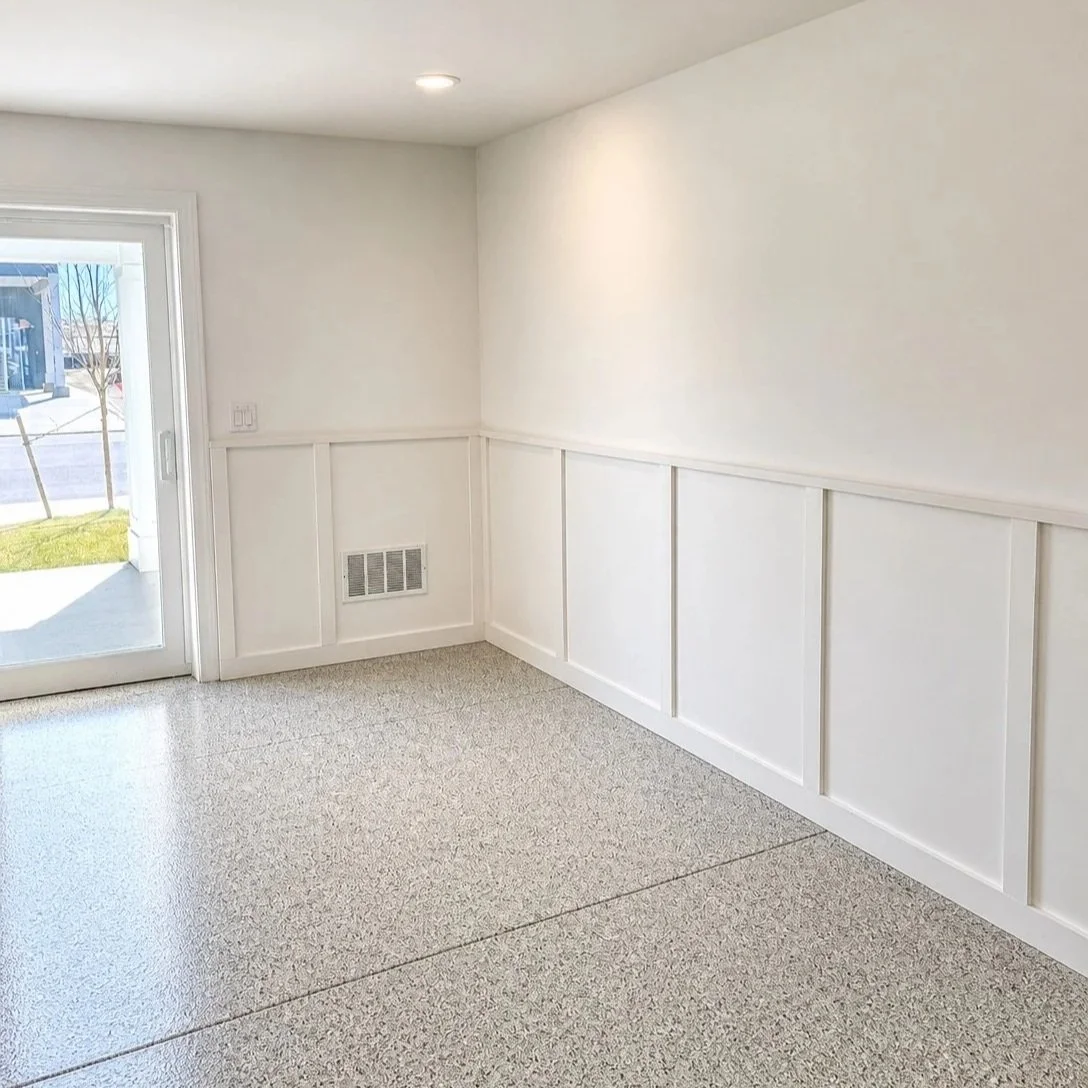 Empty room with white walls, a large sliding glass door, and a beige carpet, with a glimpse of the outdoors.