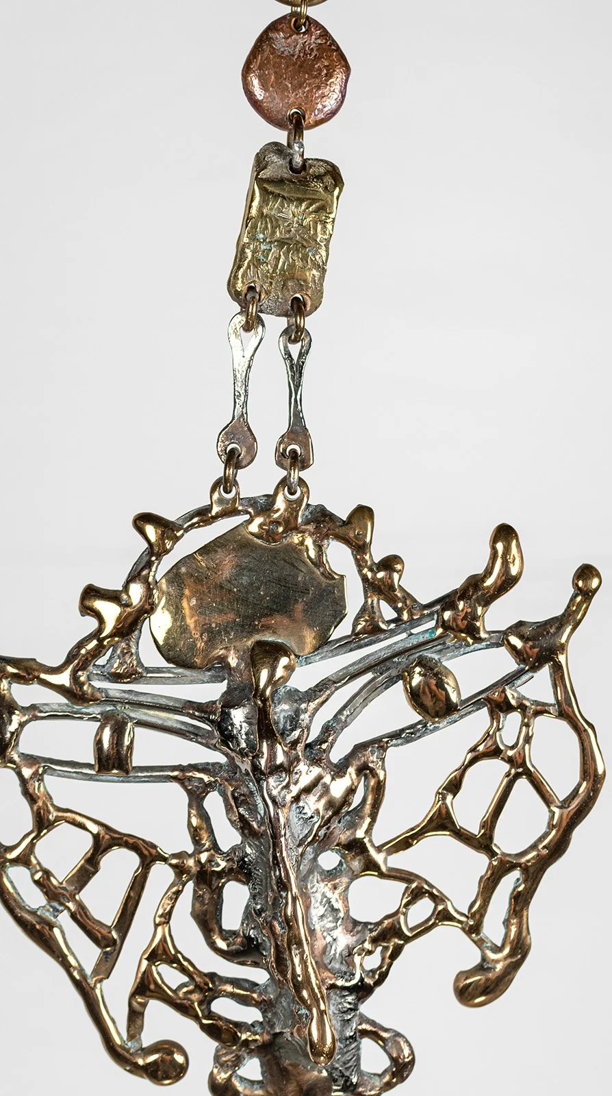 No patina here. Every metal is polished back to itself, so the surface carries light instead of colour, and every ridge left by the pour shows.