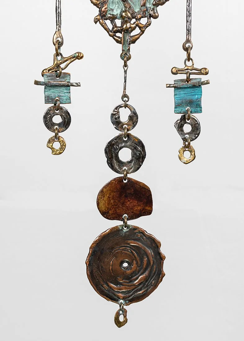 Detail-circle: lower drops

Drops of hammered brass, patinated copper, bronze, stainless steel, and amber, finishing the descent.