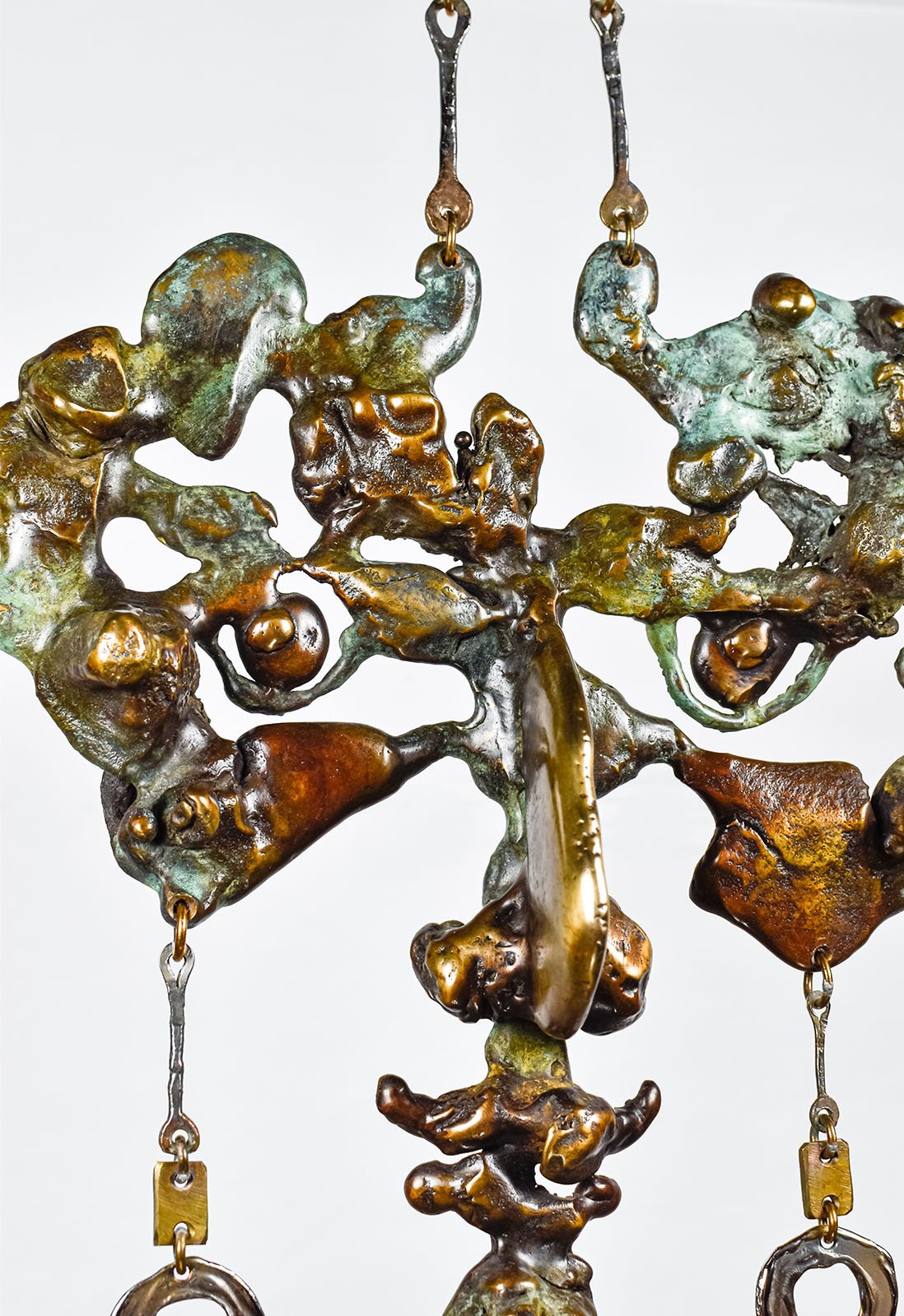 The greens come from verdigris, and the warm browns from ferric nitrate, both worked onto hot metal so the chemistry runs the same path the pour did.