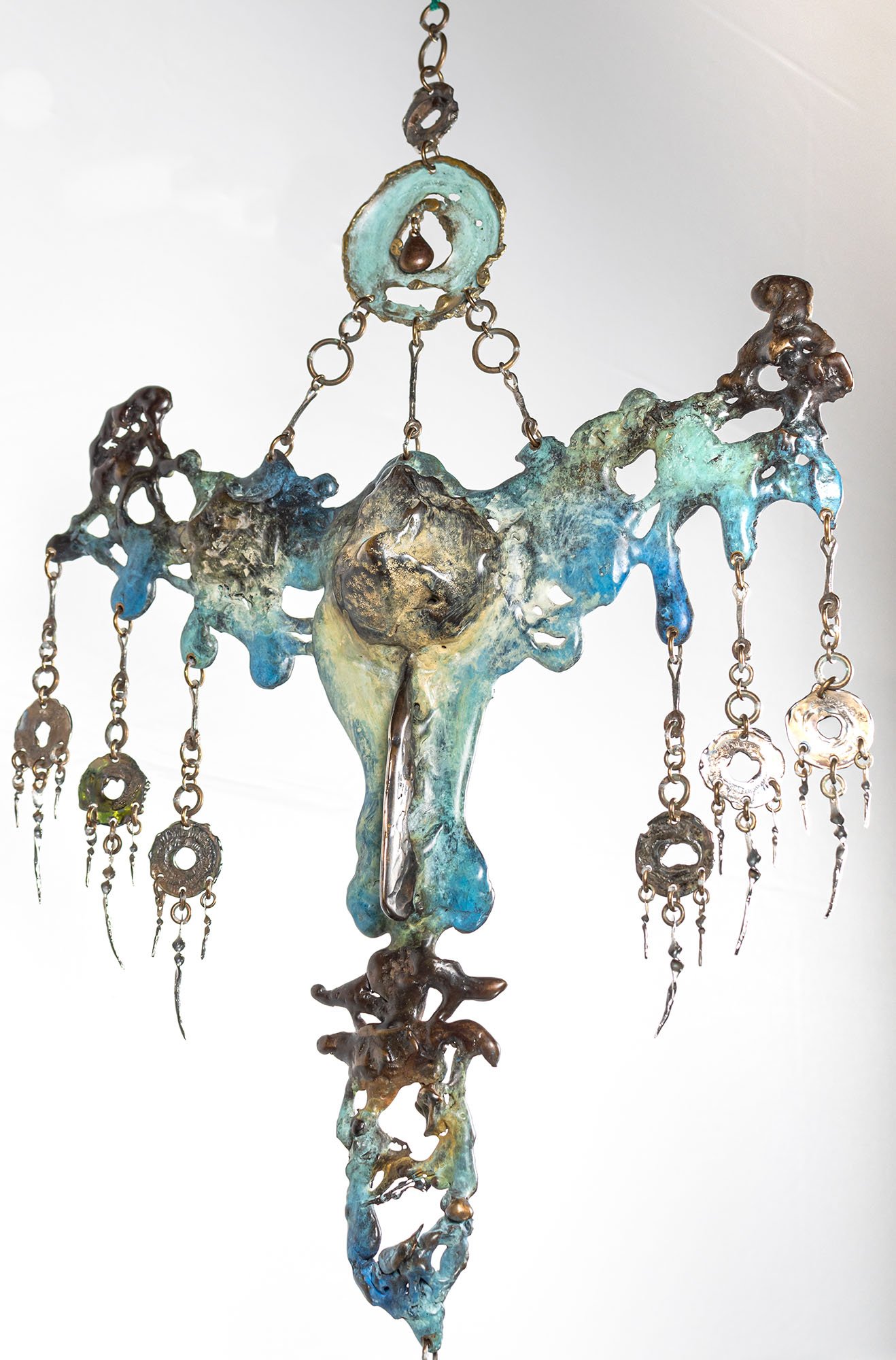 Seen from the side, the poured and assembled bronze shows its thickness. What reads flat on the wall is not flat: the metal pooled and rose where it landed.