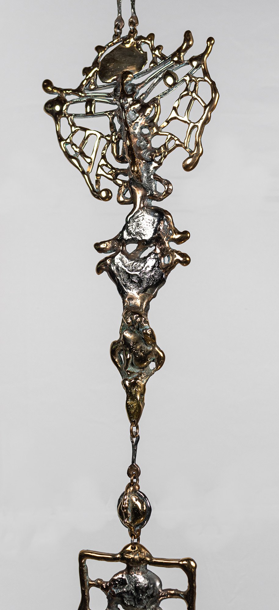 The face is made entirely of movement. The pour gives one second of it; the hours that follow continue that line with the torch, drawing element into element so the flow never breaks.