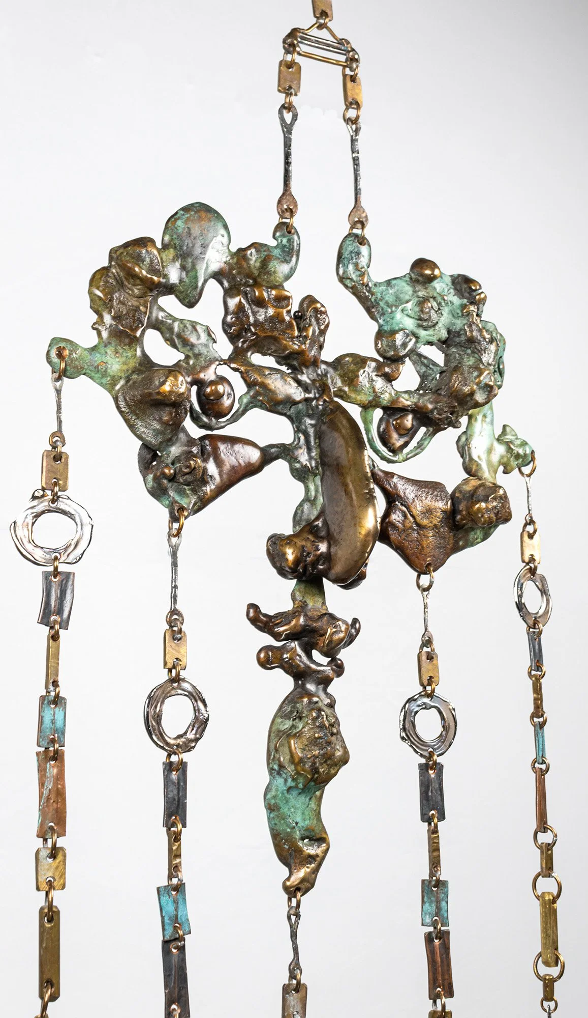 The face is made entirely of movement. The pour gives one second of it; the hours that follow continue that line with the torch, drawing element into element so the flow never breaks.
