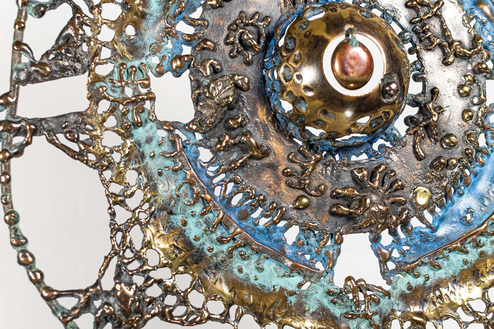 Verdigris and ferric patinas carry the blue and the burnt red.