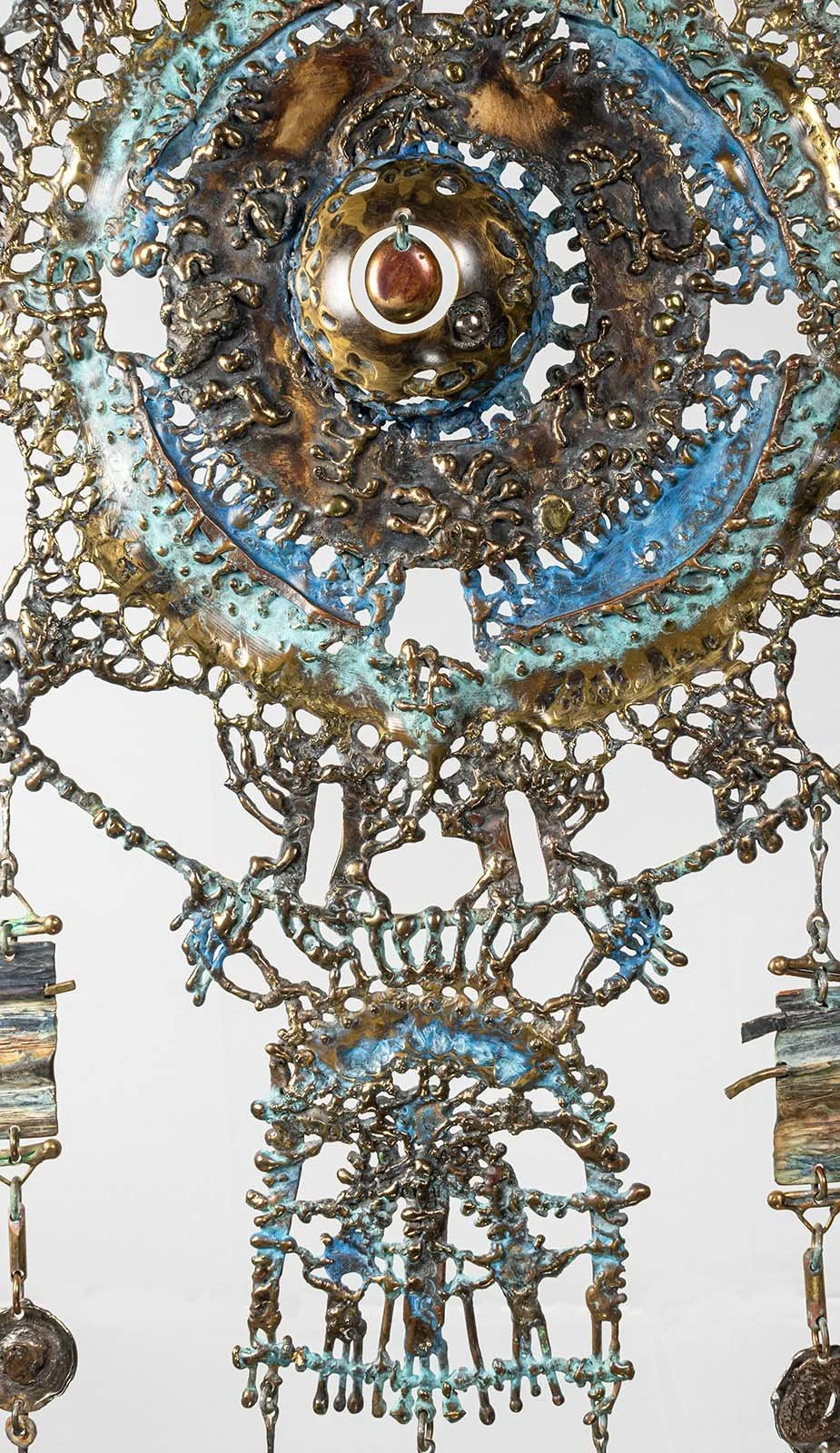 Bronze melted under the torch and drawn while it ran, laid down as ornamental embroidery around a single amber stone. 