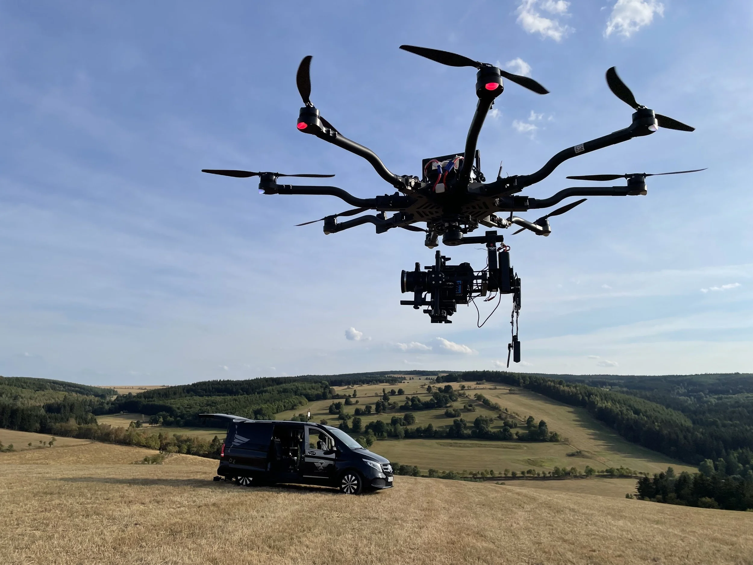 Ein blauer BMW-Coupé parkt auf einer sonnigen Parkfläche mit Solarpanelen im Hintergrund.