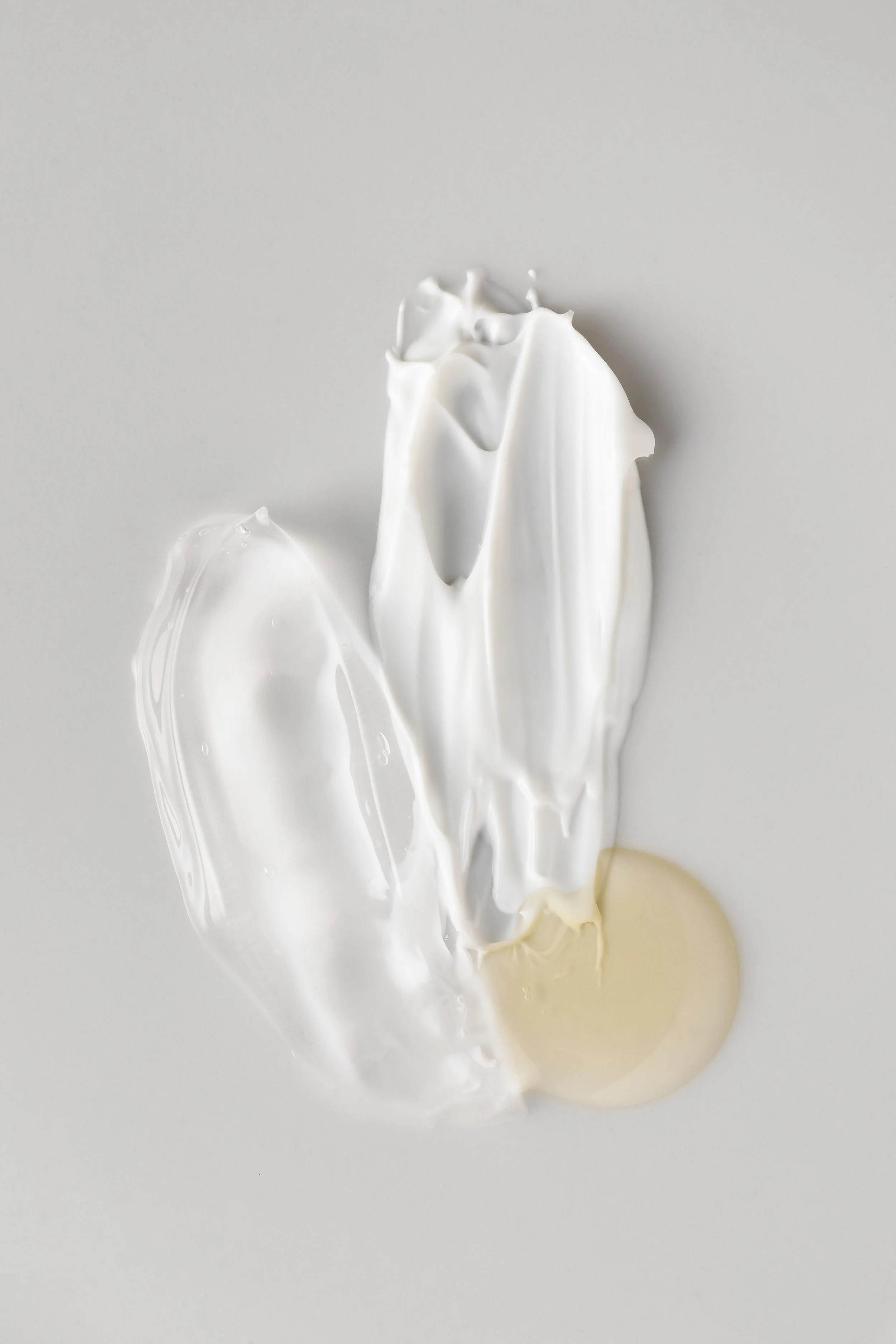 Creamsplash depicting a mix of white and light cream colors on a plain gray background.