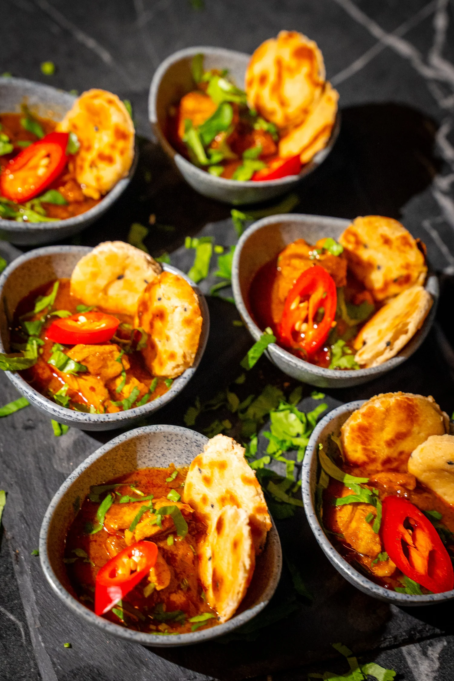 Individual savoury bowls garnished with chilli and herbs