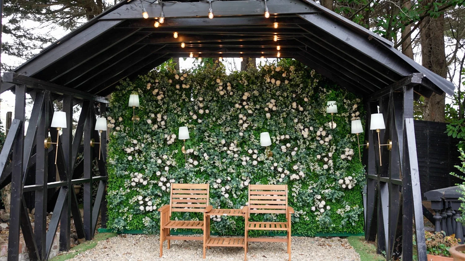 Covered ceremony setting with a floral backdrop