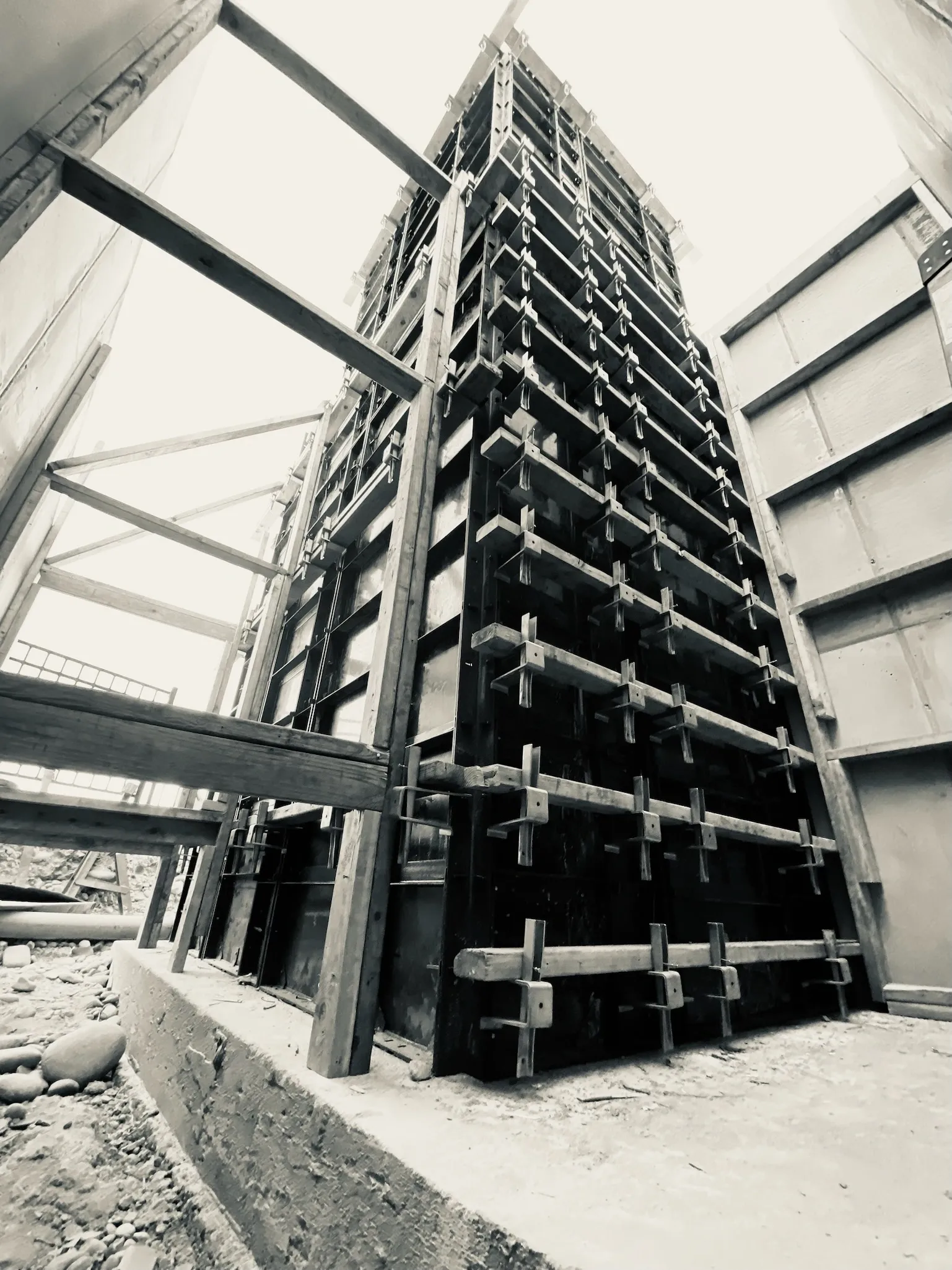 Construction site showing metal formwork and scaffolding supporting concrete for a building.