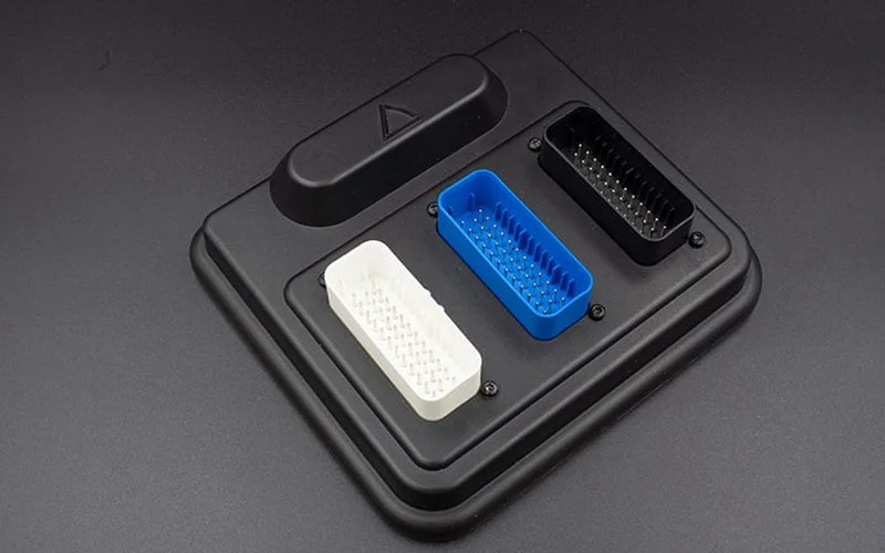 A black base with three different electronic connector ports in blue, white, and black colors.