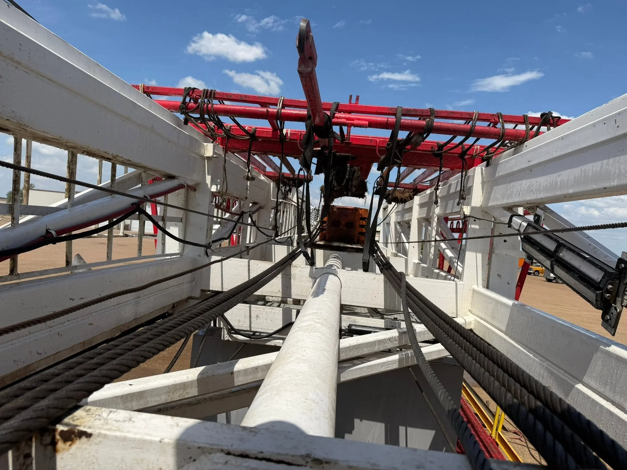 A derrick on a workover rig that was pressure washed. Years of grime, oil and mud cleaned under a blue sky.
