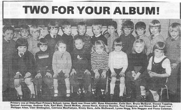 A black and white class photo of young children in two rows, with some sitting and others standing. The top of the image has bold text that reads "TWO FOR YOUR ALBUM!"