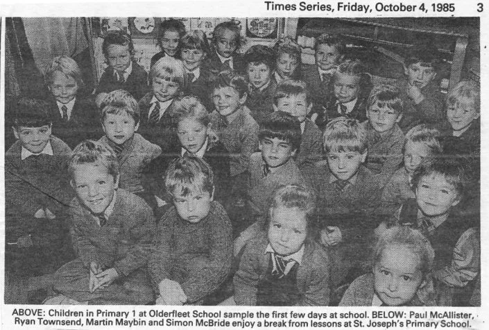 A black-and-white photo of a classroom filled with young children seated at desks, facing the camera. It was taken on October 4, 1985, and shows children from St. Joseph's Primary School, with a caption mentioning children from a primary class at Oldfleet School sampling first-day experiences.