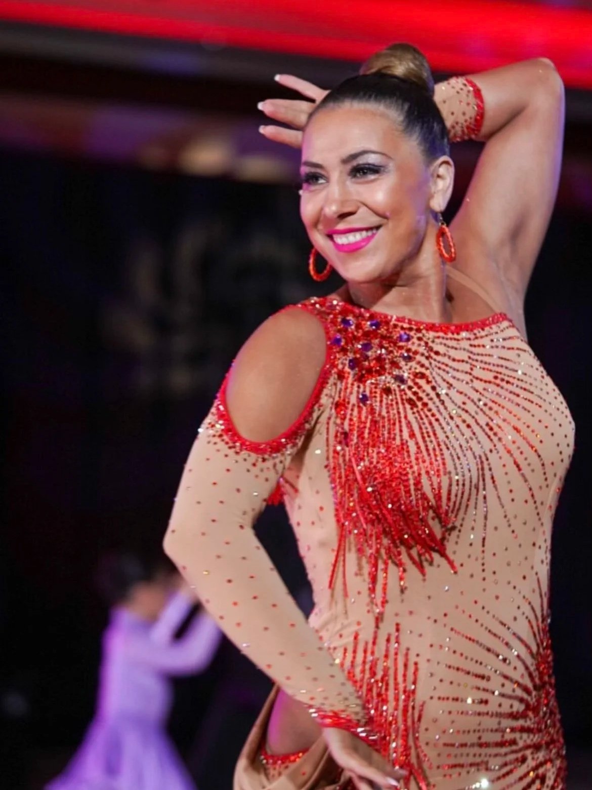 Ballroom dancer performing in a red competition dress.
