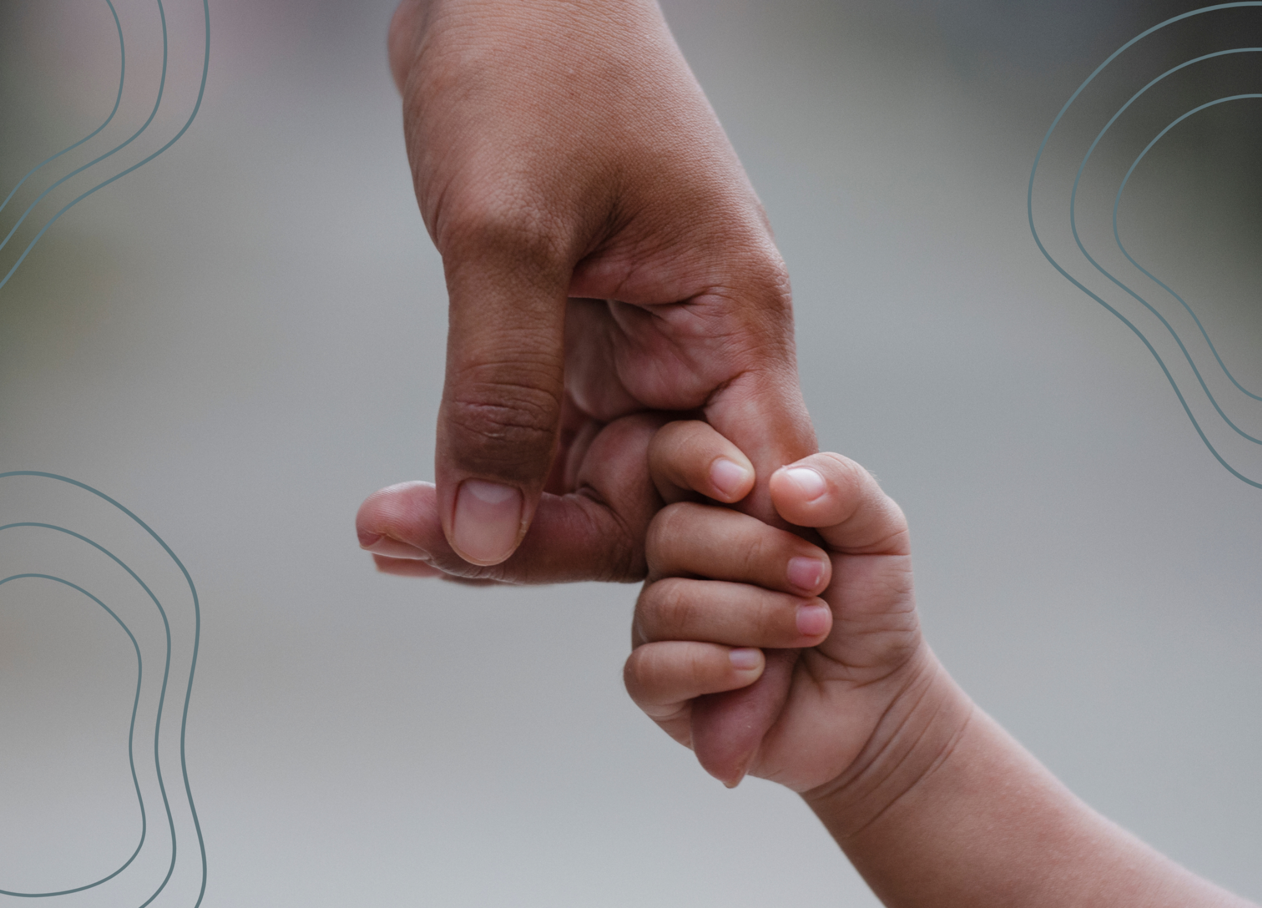 A close-up of an infant's hand holding an adult's finger.