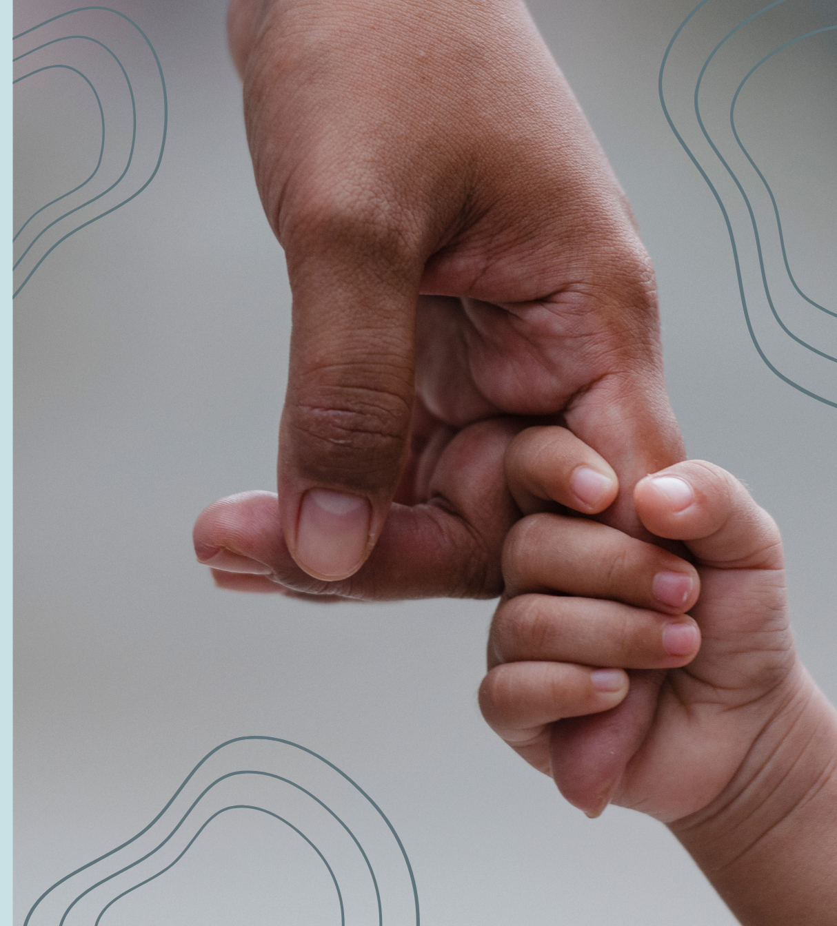 A close-up of a child's hand holding an adult's finger.