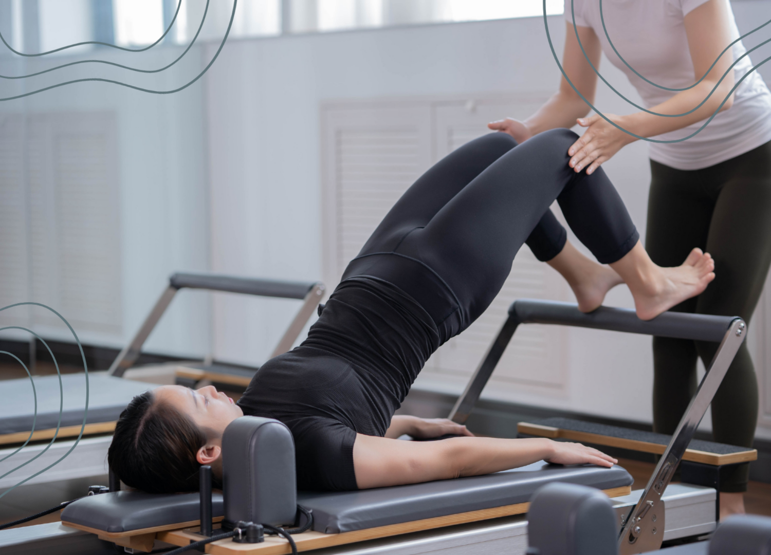 Person receiving physical therapy with a Pilates reformer machine, supported by a therapist in a clinical setting.