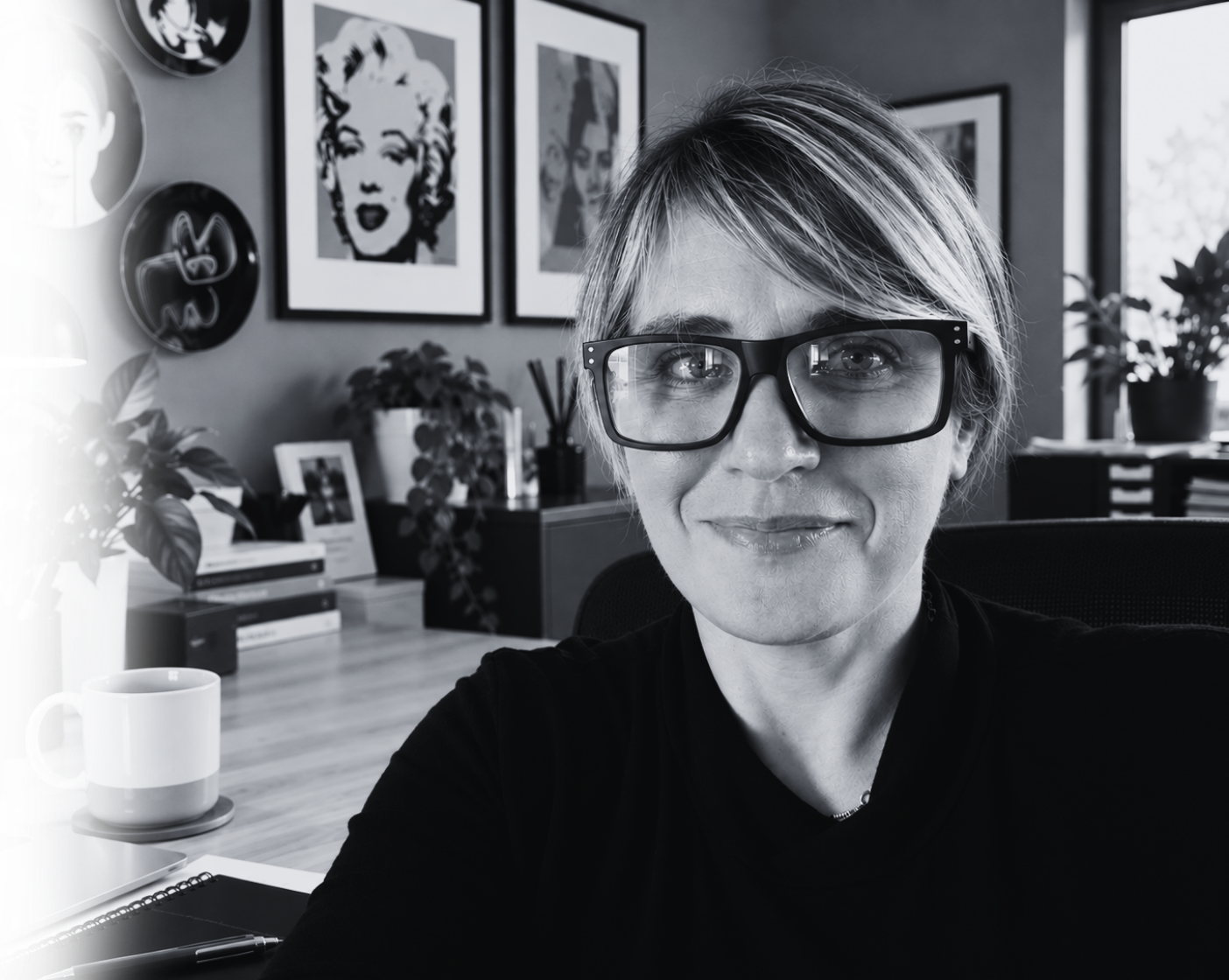 Helen- the founder of Market'ere - in front of some Andy Warhol prints, sat at her desk.