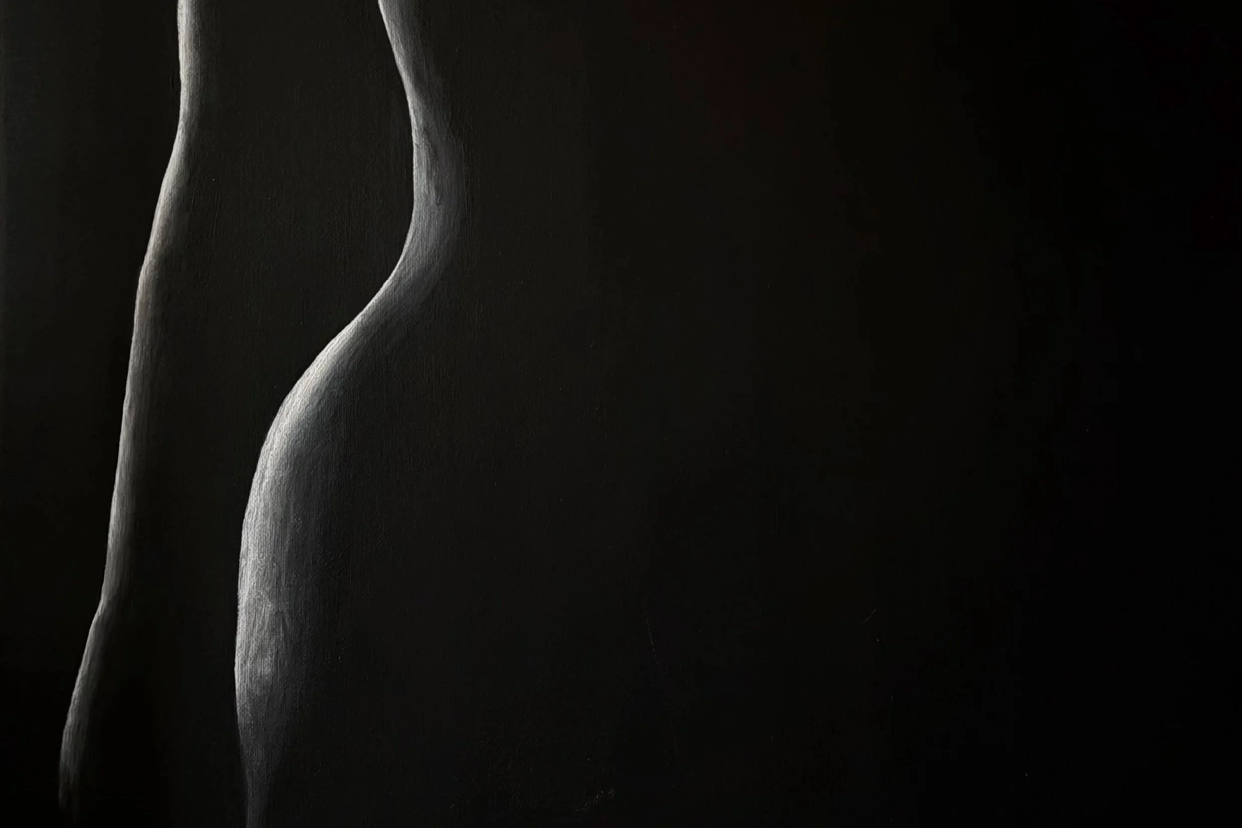 Close-up of a person's side profile, highlighting the back and buttocks, in black and white.